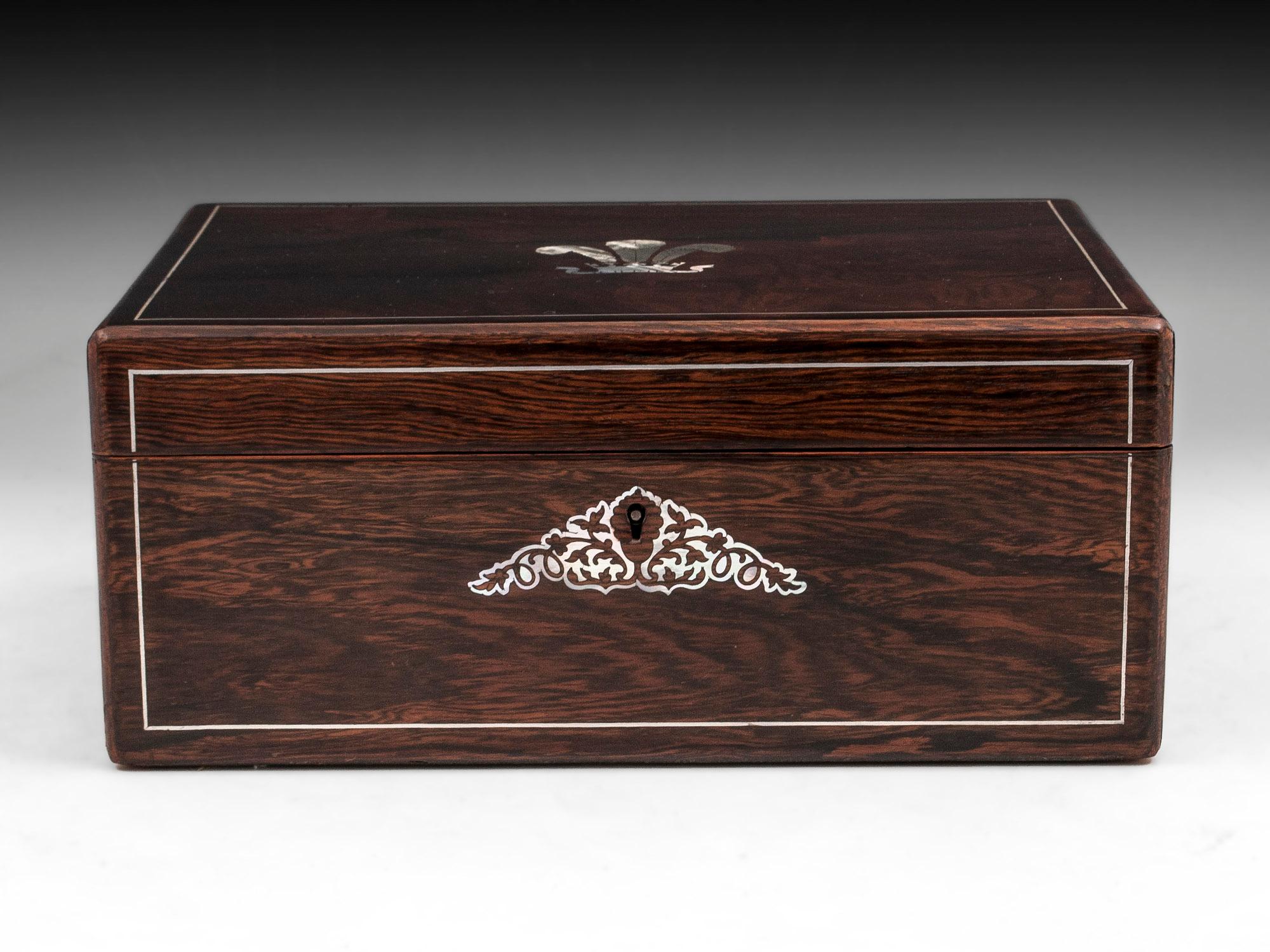 Antique jewelry box veneered in mahogany and mother of pearl inlays, with the top drawing your eye to the exquisite engraved mother of pearl 