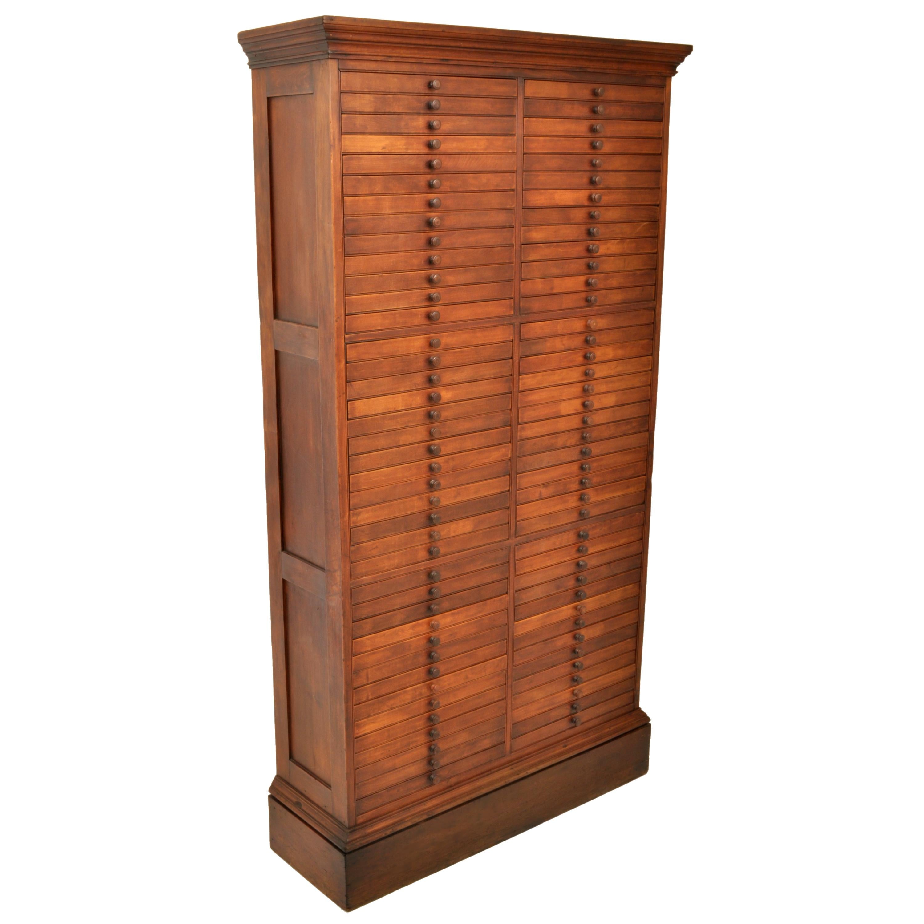 A late 19th century walnut printer's cabinet, circa 1890.
The cabinet of rare and unusual size, having a stepped crown to the top and standing on a plinth base, the cabinet having two banks of drawers, each side with 40 drawers. The sides of the
