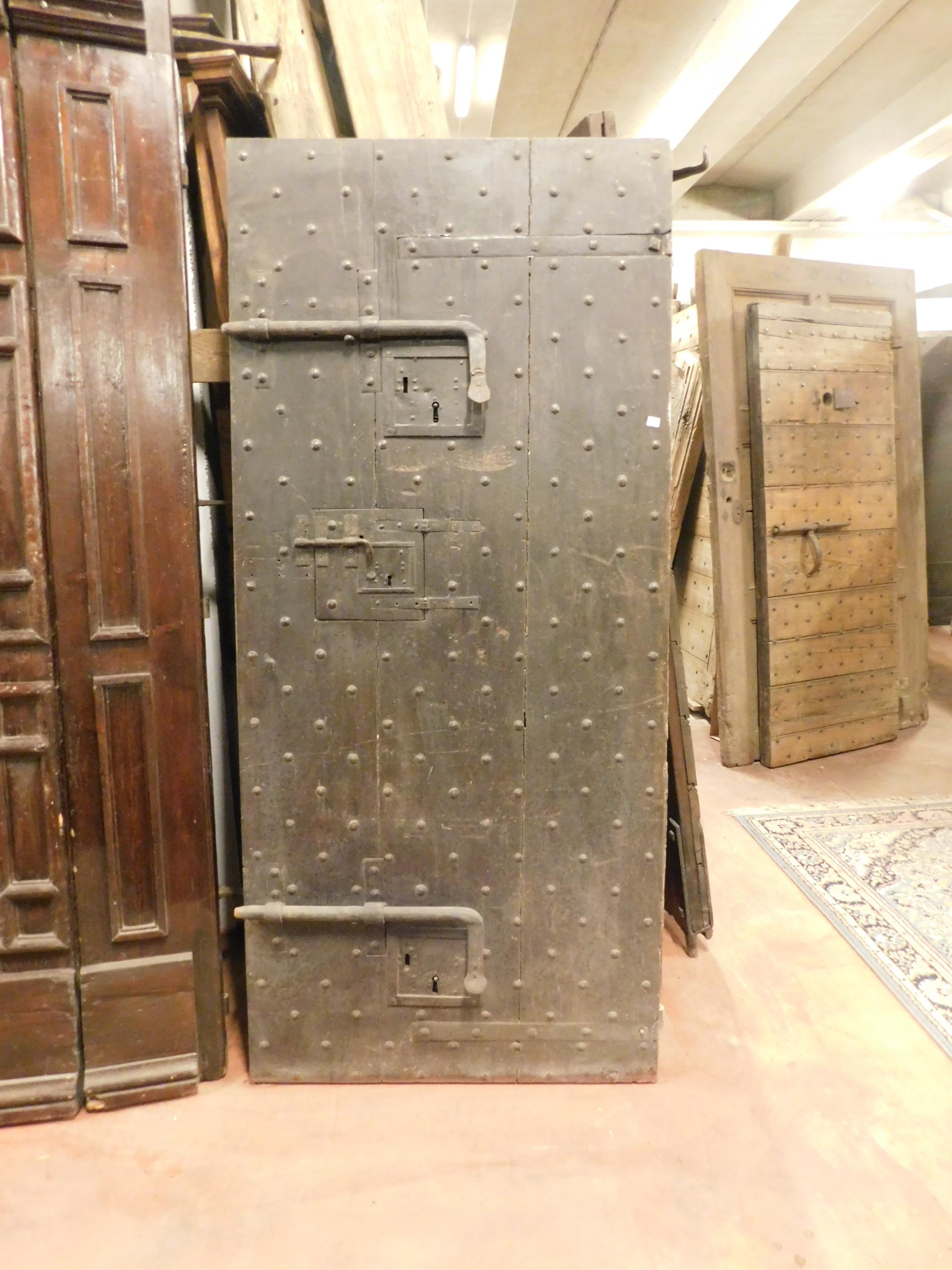Ancient prison door in black lacquered wood with ancient nails and locks, from an 18th century castle belonging to an internal prison. Very beautiful and well maintained, all the irons are original and give an idea of power, ideal for a wine cellar
