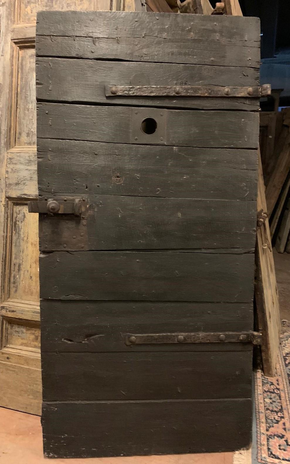 Ancient prison door, hand-lacquered black, built with nails that held the door boards together, beautiful door with peephole, original irons with closure, built at the beginning of the 19th century for a historic prison in Italy.
smooth back in raw