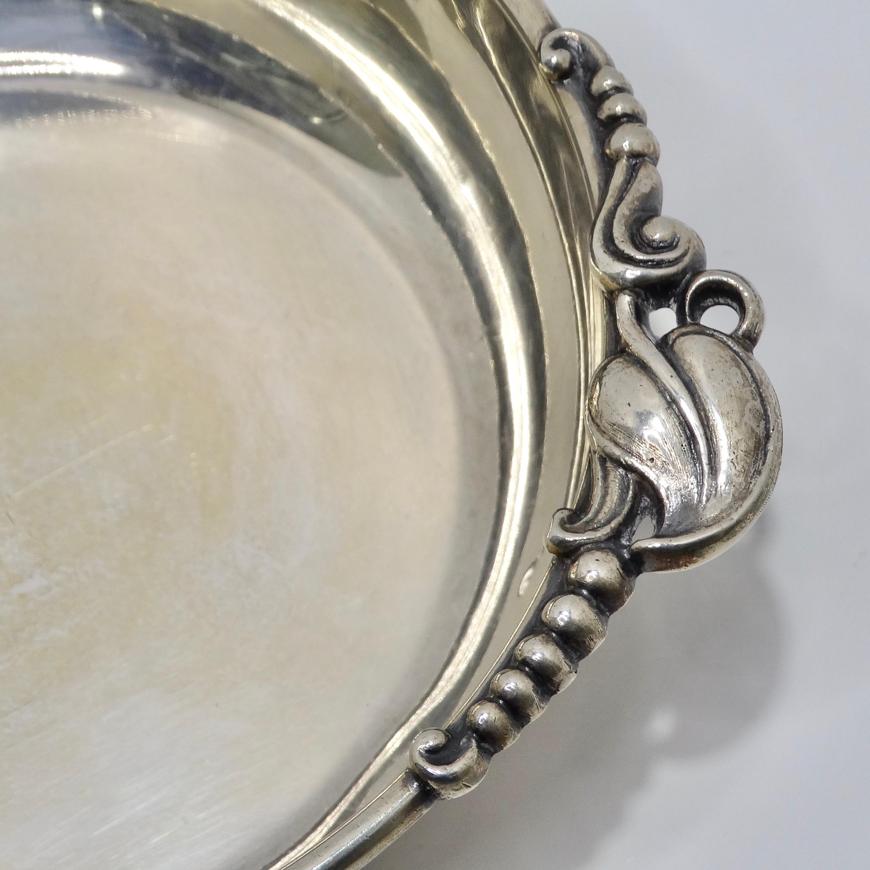 Introducing the Antique Pure Silver Bowl, a breathtaking piece from the early 1900s that epitomizes timeless elegance and luxury.

Crafted with exquisite attention to detail, this pure silver bowl boasts ornate leaf motifs adorning its handles,