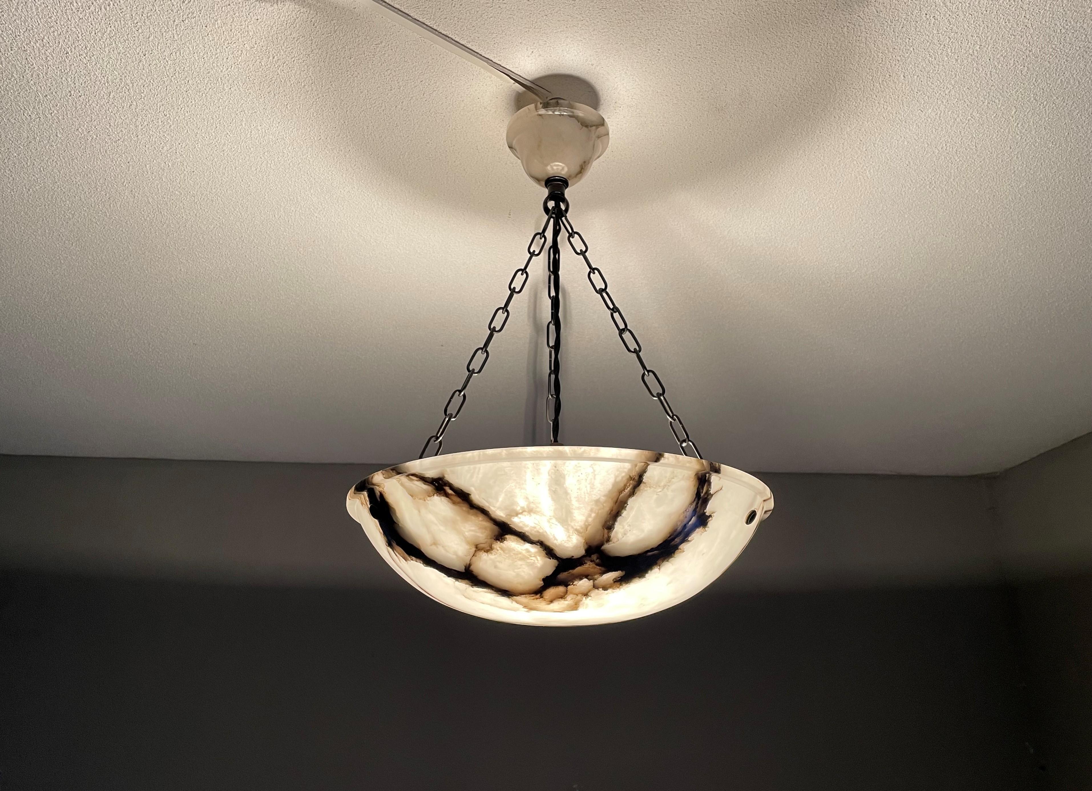 Small and timeless Art Deco pendant light with perfect black veins.

With early 20th century lighting as one of our specialities, finding an excellent condition and highly attractive fixture always makes our day. This practical size specimen has