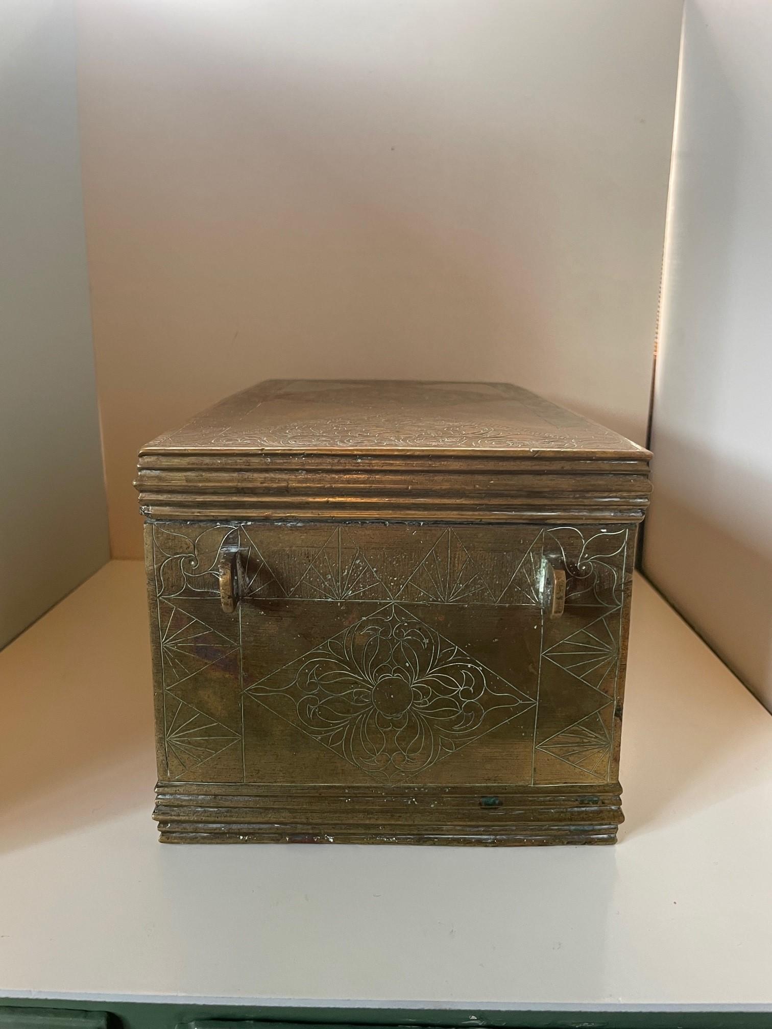 Antique solid brass lidded box from Qajar Iran, c. 20th century. Absolutely stunning piece with beautifully intricate engraving detail throughout. A diamond engraved pattern runs throughout that encloses floral engravings. Two handles on both sides