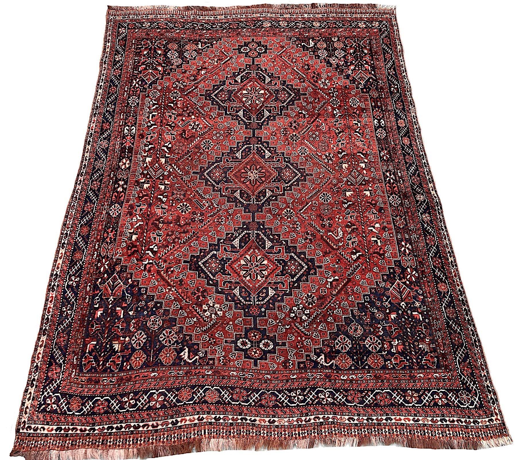Ein ungewöhnlich großer antiker Gaschgai-Teppich, handgewebt von dem gleichnamigen Nomadenstamm um 1920. Das Design zeigt 3 kleine Medaillons auf einem Terrakotta-Feld mit stilisierten Blumen und Figuren, umgeben von einer indigoblauen Bordüre aus