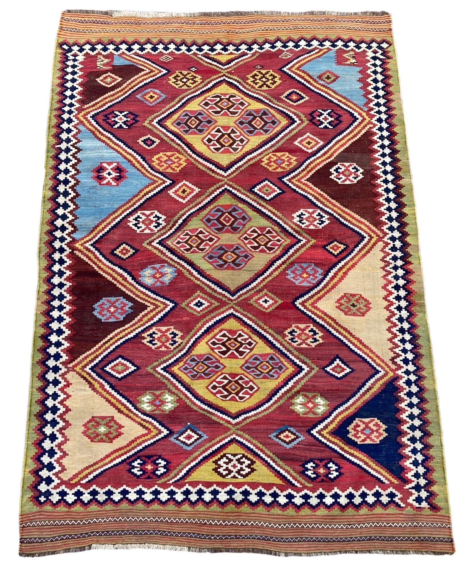 An outstanding antique Qashqai Kilim, handwoven by the eponymous nomadic tribe circa 1890 with a geometrical 3 medallion design on a terracotta field. An unusually small size with fabulous natural colours and a highly collectible piece.

Size: