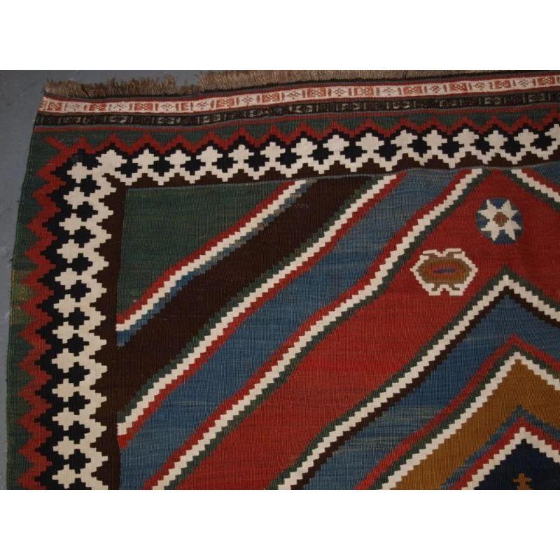 A really outstanding Persian Qashqai kilim from South West Persia with very bold graphic design and wonderful natural dye colours throughout.

Excellent condition, very slight wear, both ends retain the original checkerboard end finishes. Hand