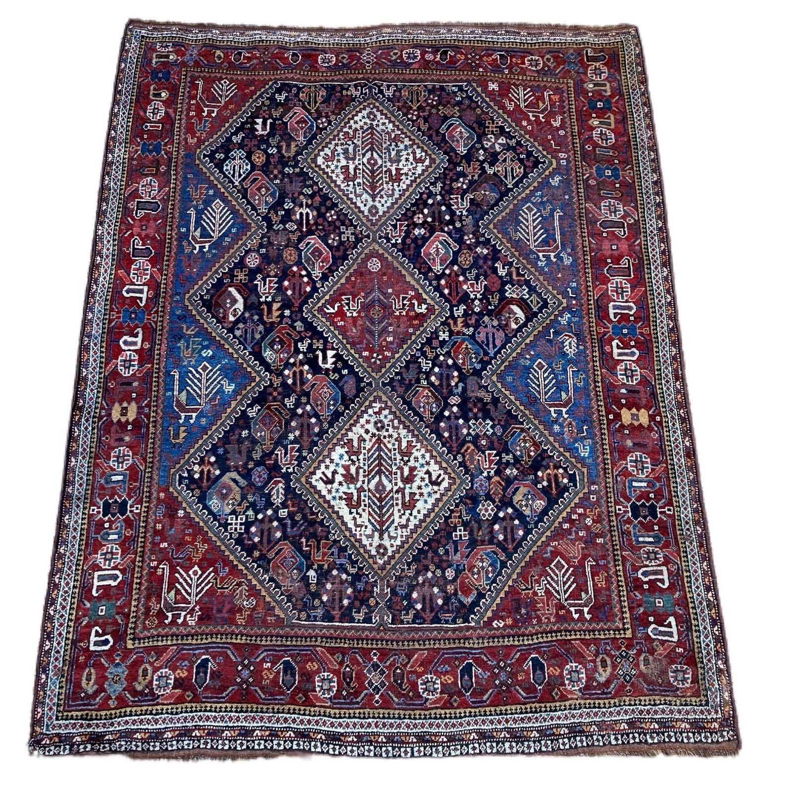 A fabulous antique Qashqai rug, handwoven by the eponymous nomadic tribe circa 1900 with a 3 medallion geometrical design on a dark indigo field and great secondary colours. A charming tribal piece with numerous birds throughout the field (see
