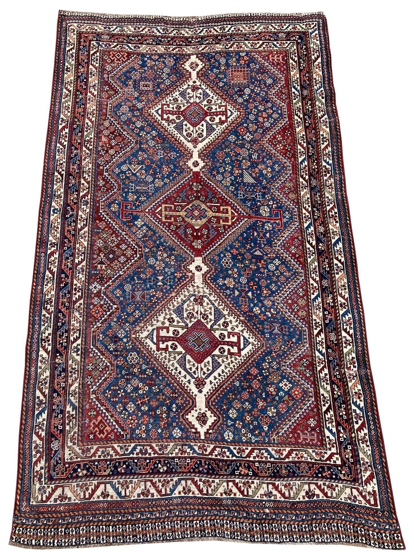 Un fabuleux tapis Qashqai ancien, tissé à la main par la tribu nomade éponyme vers 1900, avec un motif à 3 médaillons sur un champ bleu marine et de superbes couleurs secondaires. Notez les petites figures dans tout le champ (voir les