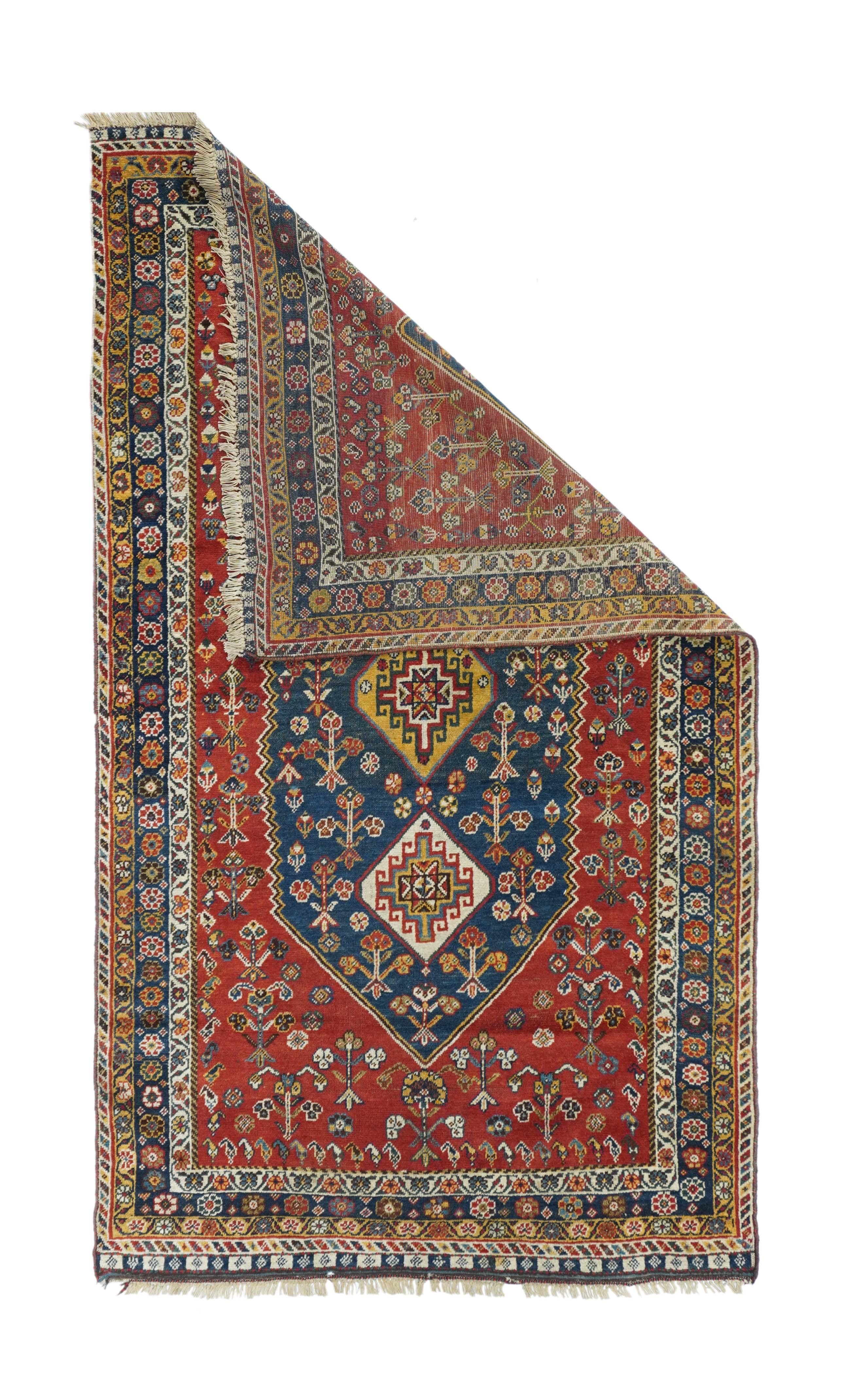 Antique Qashqai rug, measures : 3'10'' x 7'1''. The red, subfield, with unidirectional flowers, hosts a hexagonal navy subfield centred by three stretched hexagonal Memling gul medallions in cream and straw. Royal blue main band with rosettes;