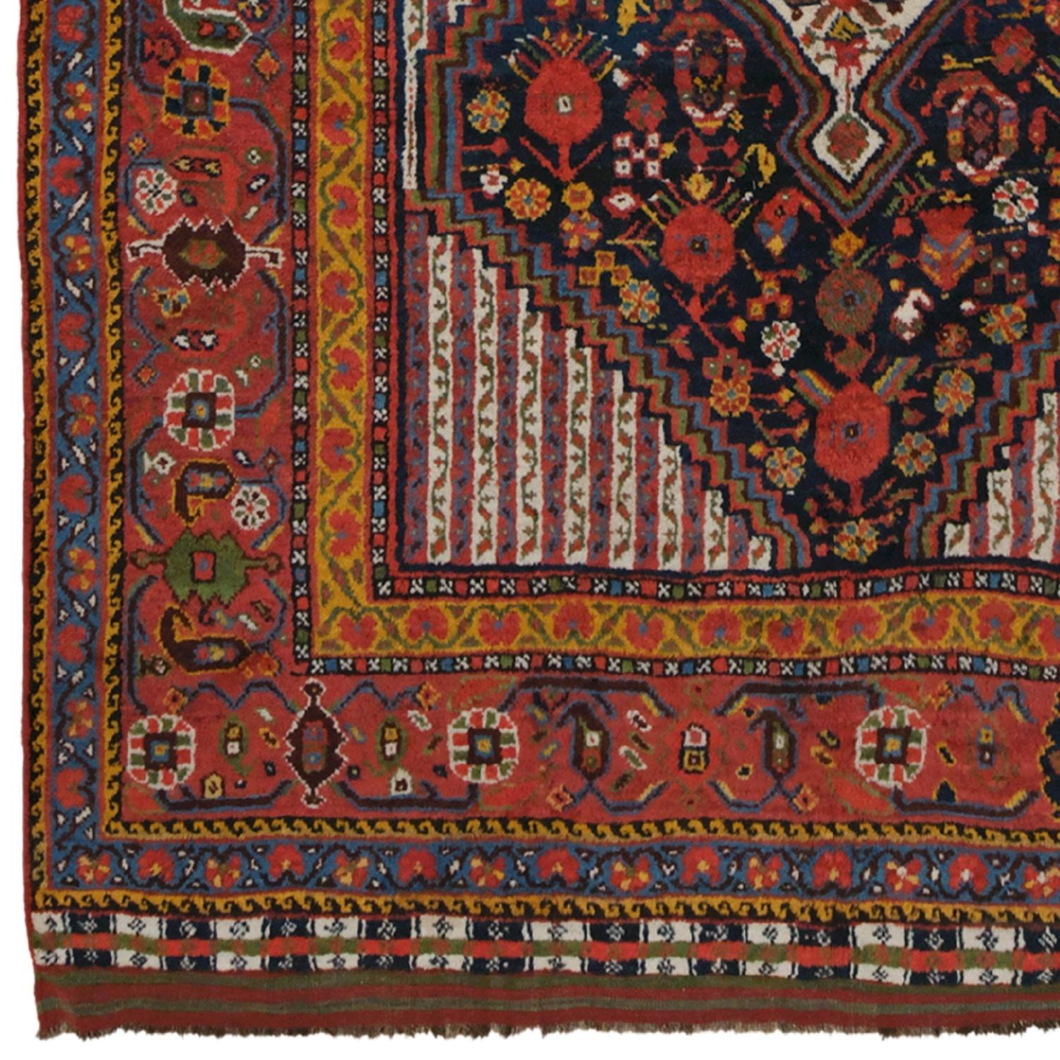 Ce rare tapis Qashqai date de la fin du 19e siècle et attire l'attention par ses motifs uniques tissés à la main. Au centre du tapis se trouve un grand médaillon triangulaire décoré de motifs floraux blancs et rouges. Le médaillon est entouré de