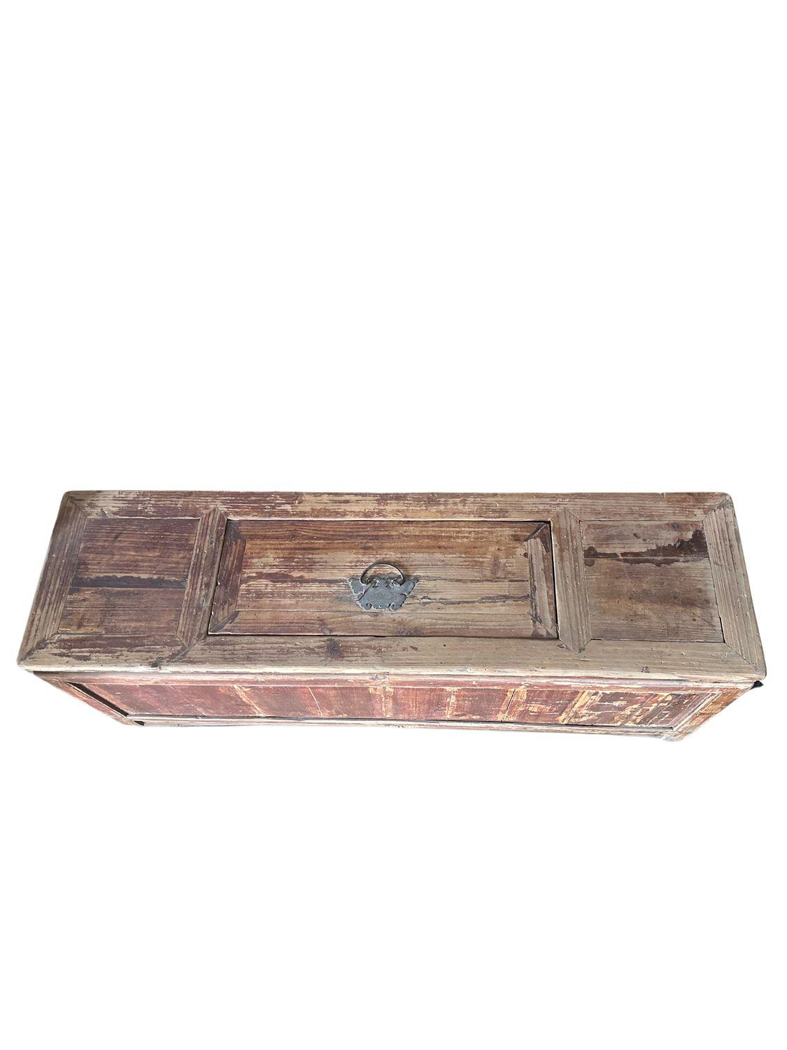 This antique Qing Dynasty elm chest, dating back to circa 1830, is a remarkable piece of history and craftsmanship. Made from solid elm wood, it features a rustic, weathered appearance that adds to its charm and authenticity. The chest's rectangular