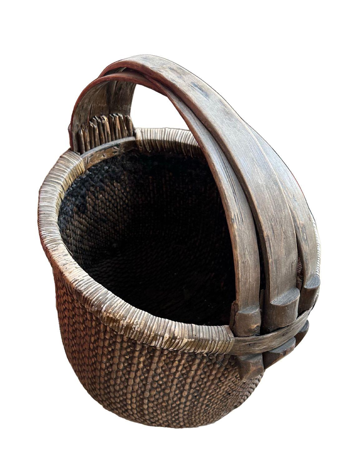 This antique rattan basket, dating back to circa 1790 during the Qing Dynasty, is a stunning example of traditional Chinese craftsmanship. The basket features intricate, tight weaving that showcases the skill and artistry of the period. The elm wood