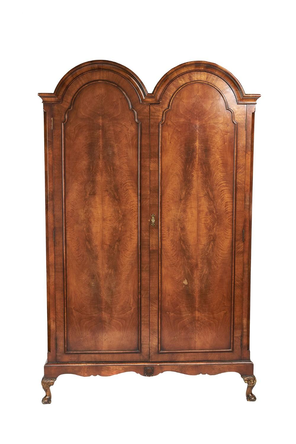 Antique quality burr walnut two door double dome wardrobe having a quality double dome shaped moulded cornice above a pair of crossbanded burr walnut shaped moulded doors opening to reveal a large hanging storage compartment. It boasts canted