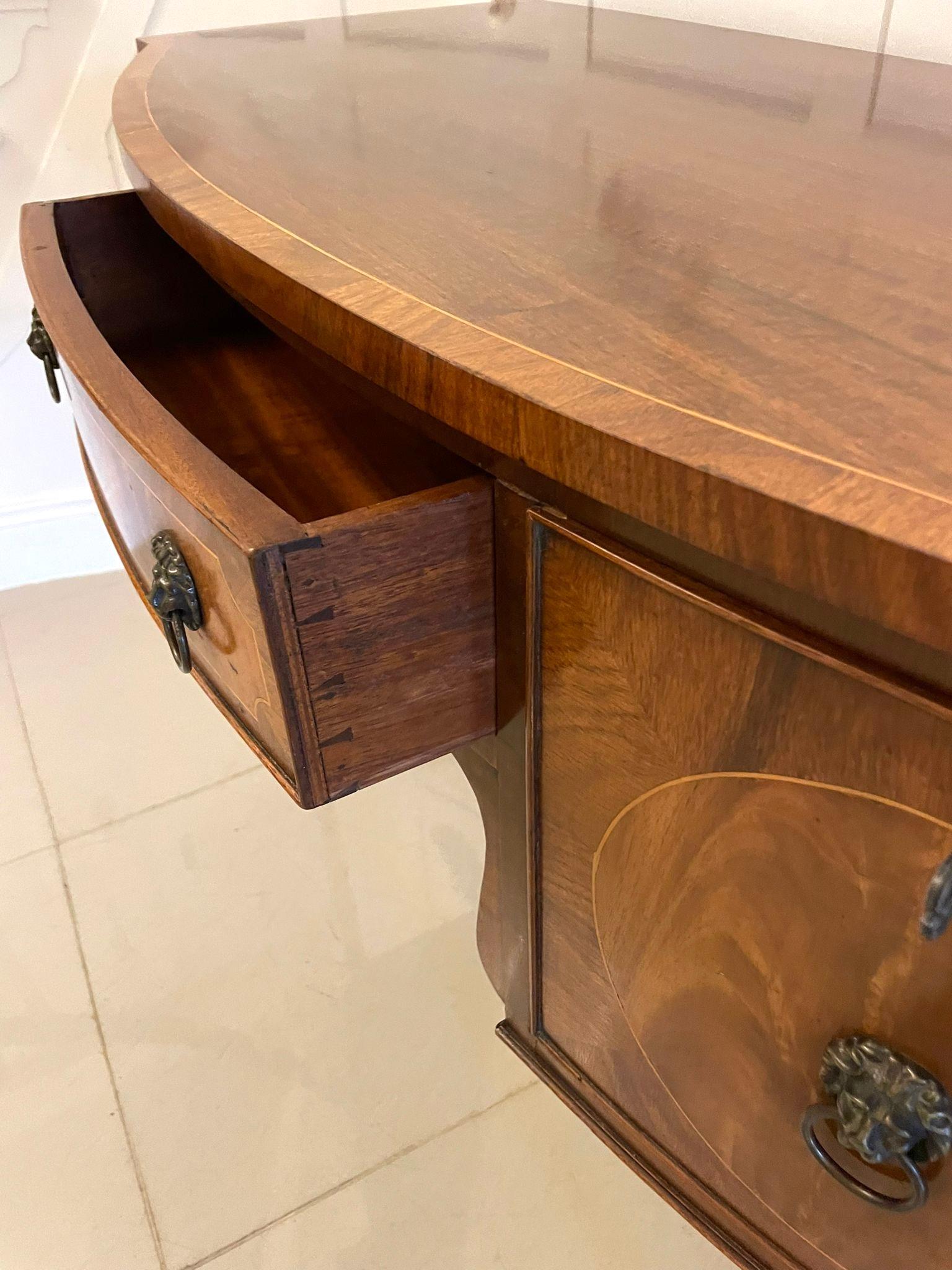 Antique quality figured mahogany bow fronted sideboard having a quality figured mahogany bow fronted top crossbanded in satinwood inlay, cockbeeded bow fronted figured mahogany drawer to the centre with satinwood inlay and original lions head