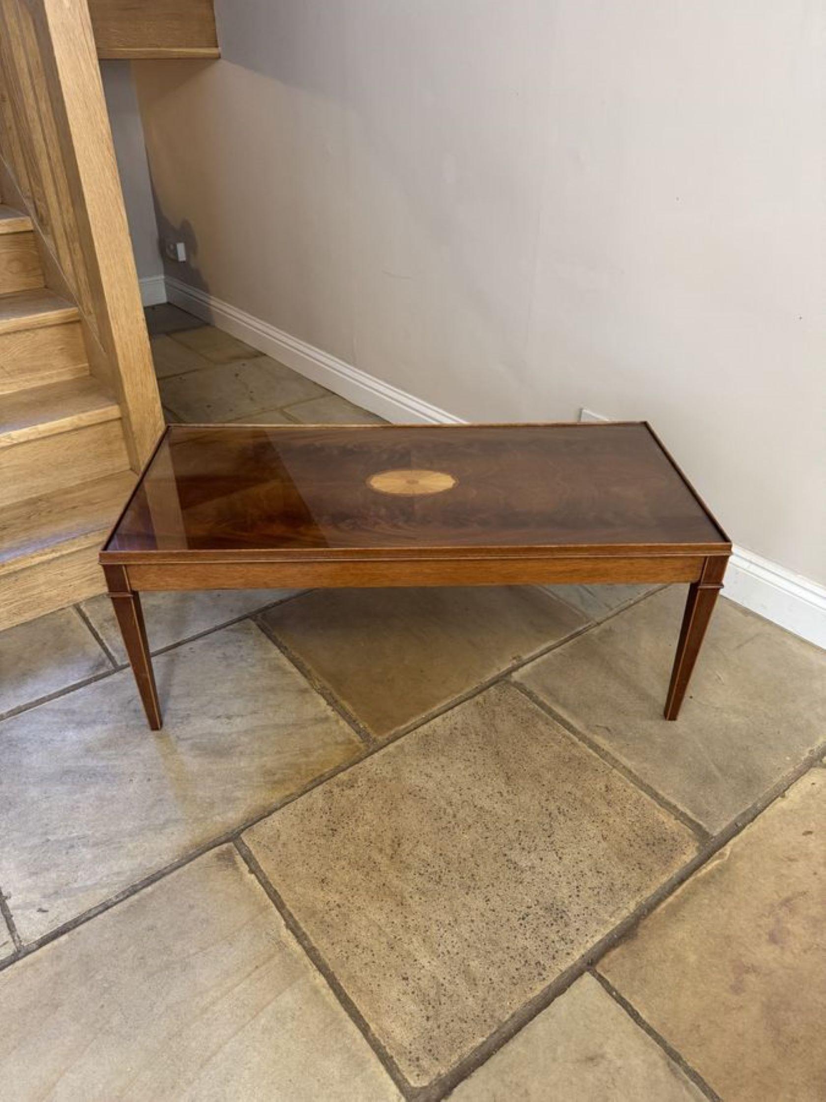 Table basse ancienne en acajou figuré et marqueté, avec un plateau en acajou figuré de qualité avec une coquille incrustée de bois satiné au centre, recouvert d'un plateau amovible en verre entouré d'un bord mouluré, une frise en acajou reposant sur