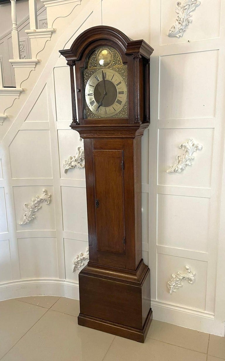 Antique quality oak three train chiming brass face longcase clock signed John Simpson London 
having a quality oak case with an arched top, long door to the case standing on a plinth base with a brass arched dial, Roman numerals, original hands, 8