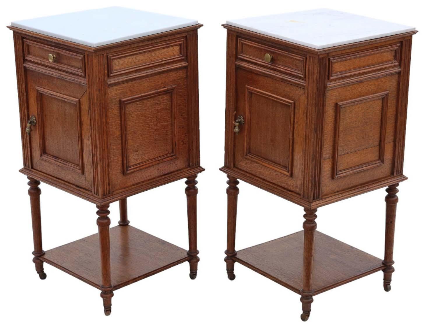Antique, high-quality pair of French oak bedside tables/cupboards dating from circa 1920. Featuring loose-laid marble tops, as is customary for this style.

These pieces are sturdy and robust, with no loose joints or signs of woodworm. They possess