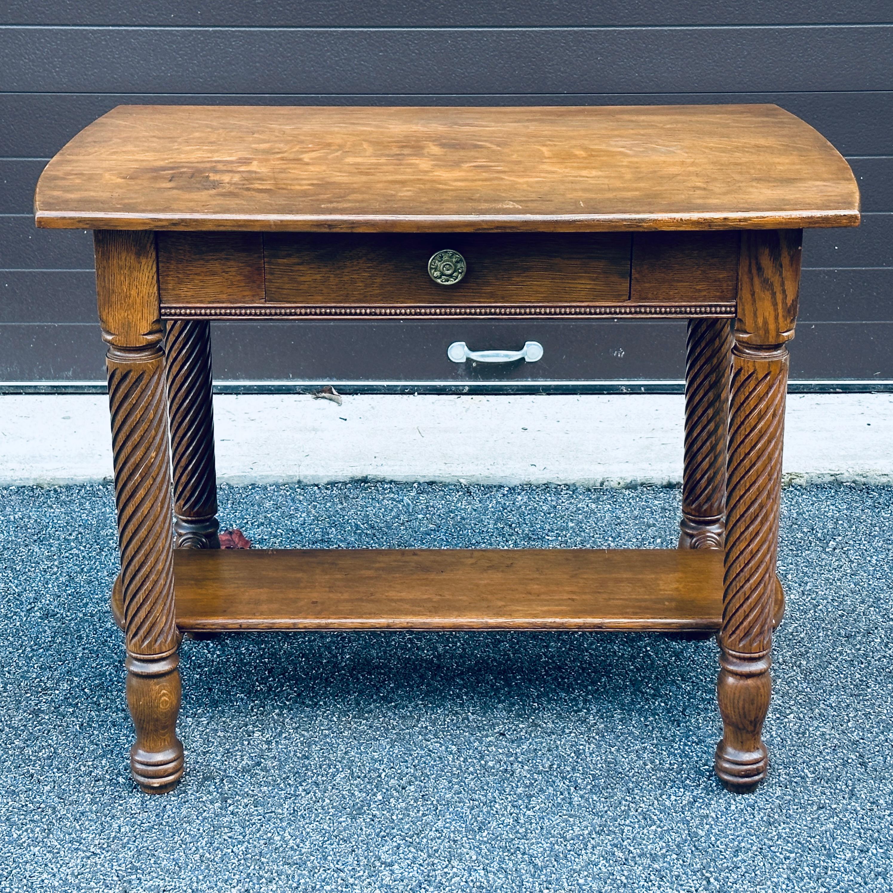 Antique quartersawn solid oak library table with spiral twist carved legs and single drawer.