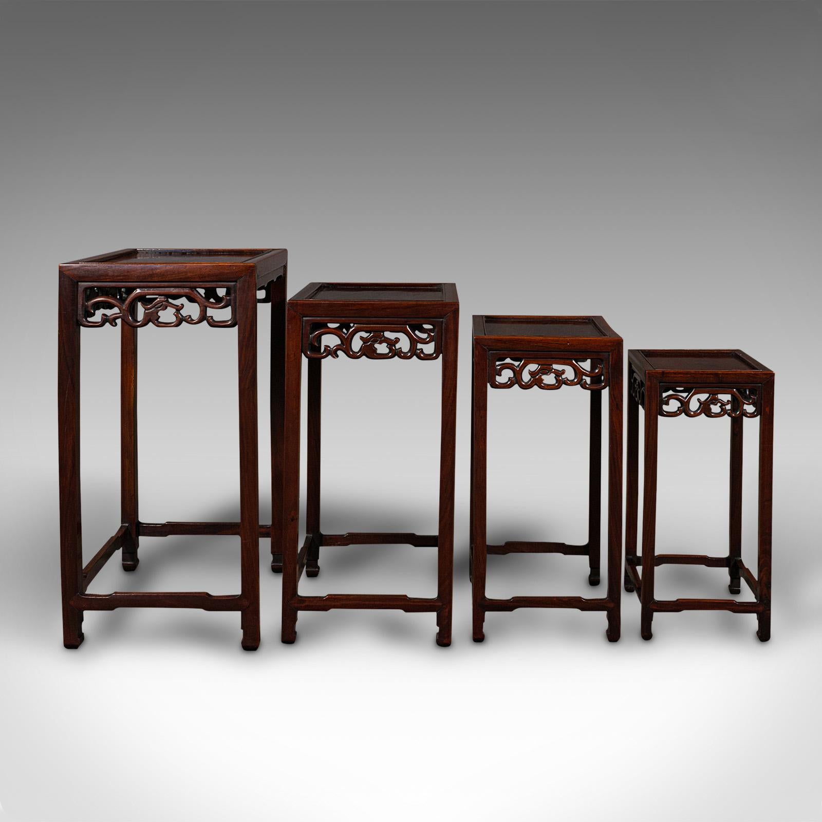 This is an antique quartetto of nesting tables. A Chinese, rosewood set of occasional tables, dating to the late Victorian period, circa 1900.

Of quality craftsmanship, with appealing late 19th century Chinese motif
Displaying a desirable aged