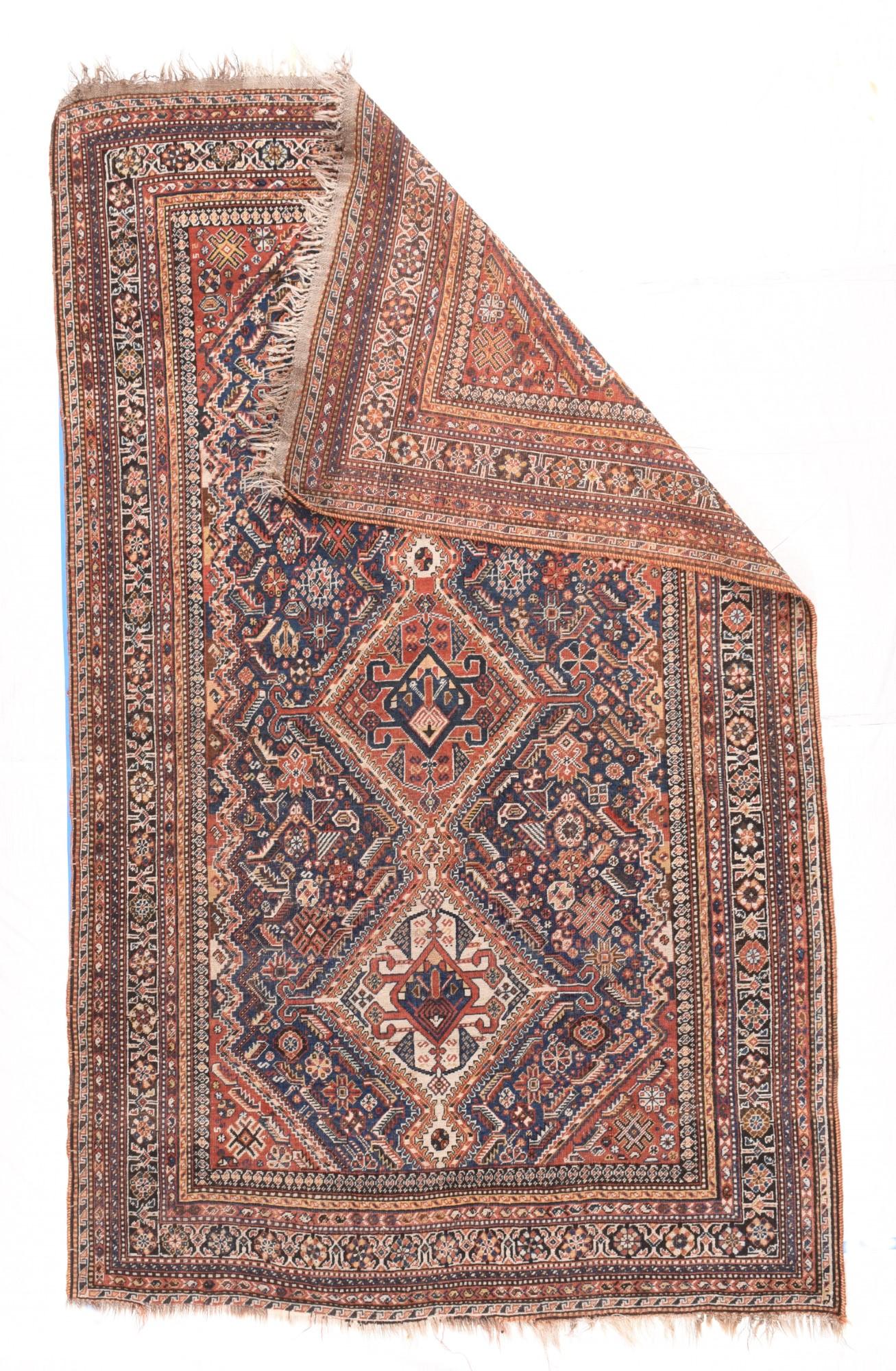 Antique Quashkai rug measures 5' x 8'2''. Probably from the Rahimlu Qashghai suibtribe as indicated by the bracket and rosette main border, this SW Persian long tribal scatter shows an ivory and rust-red three diamond pole medallion, each section