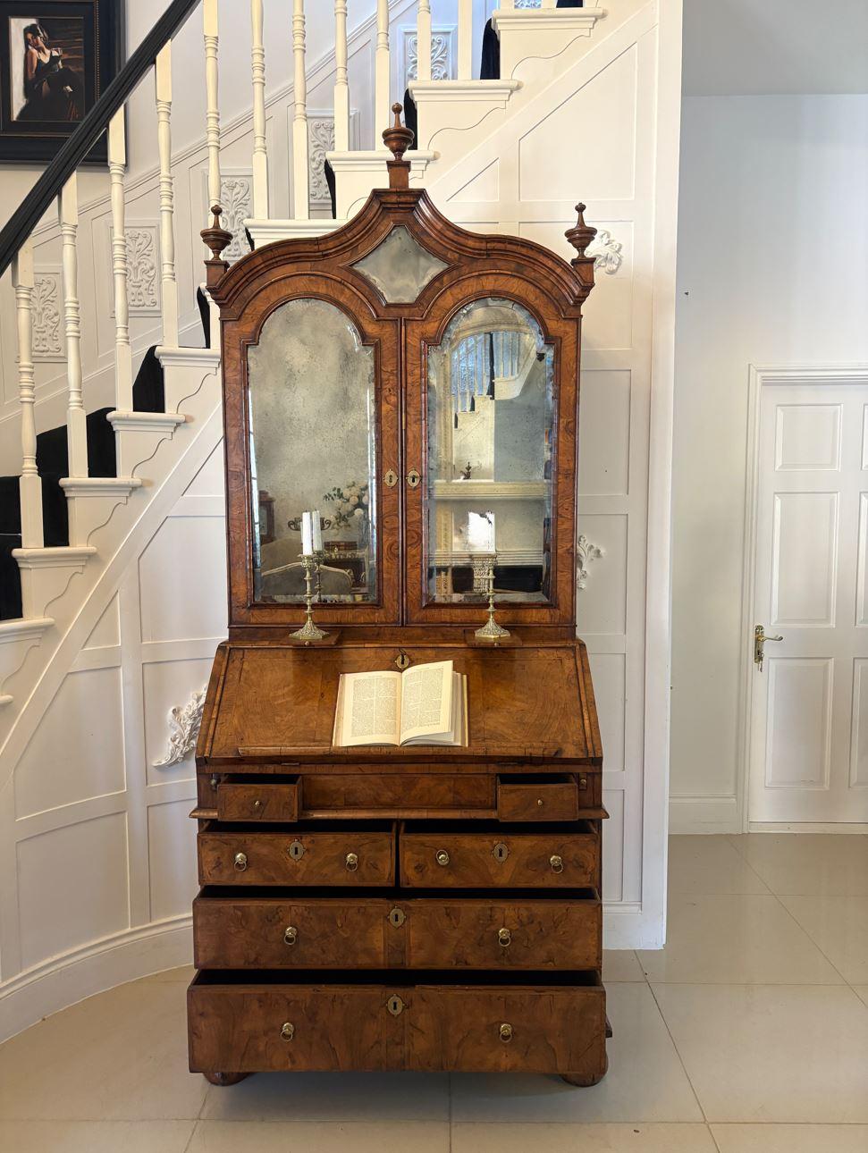 Antique Queen Anne fantastic quality burr walnut and featherbanded bureau bookcase having a shaped moulded top with three original turned finals above a pair of burr walnut bevelled edge mirror doors opening to reveal a fitted top, original candle