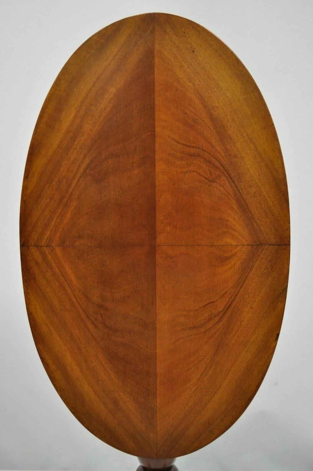 Antique Queen Anne Federal Style Mahogany Oval Tilt Top Side Tea Table. Item features a Queen Anne tripod base, oval tilt top, mahogany wood construction, beautiful wood grain, quality American craftsmanship. Circa Early 20th Century. Measurements: