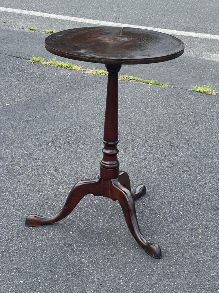 Prova il fascino dell'eleganza coloniale con questo antico portacandele a piede di serpente di Queen Anne, caratterizzato da un intrigante piano in biscotto di vecchia crescita. I mobili Queen Anne, uno stile molto amato risalente all'inizio del