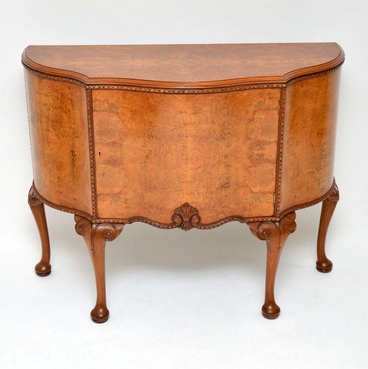 This antique Queen Anne style burr walnut cabinet has a wonderful warm mellow colour & is in excellent condition, dating from the 1920s period. It has a serpentine shaped front with a single door cupboard & lots of storage inside. The top and the