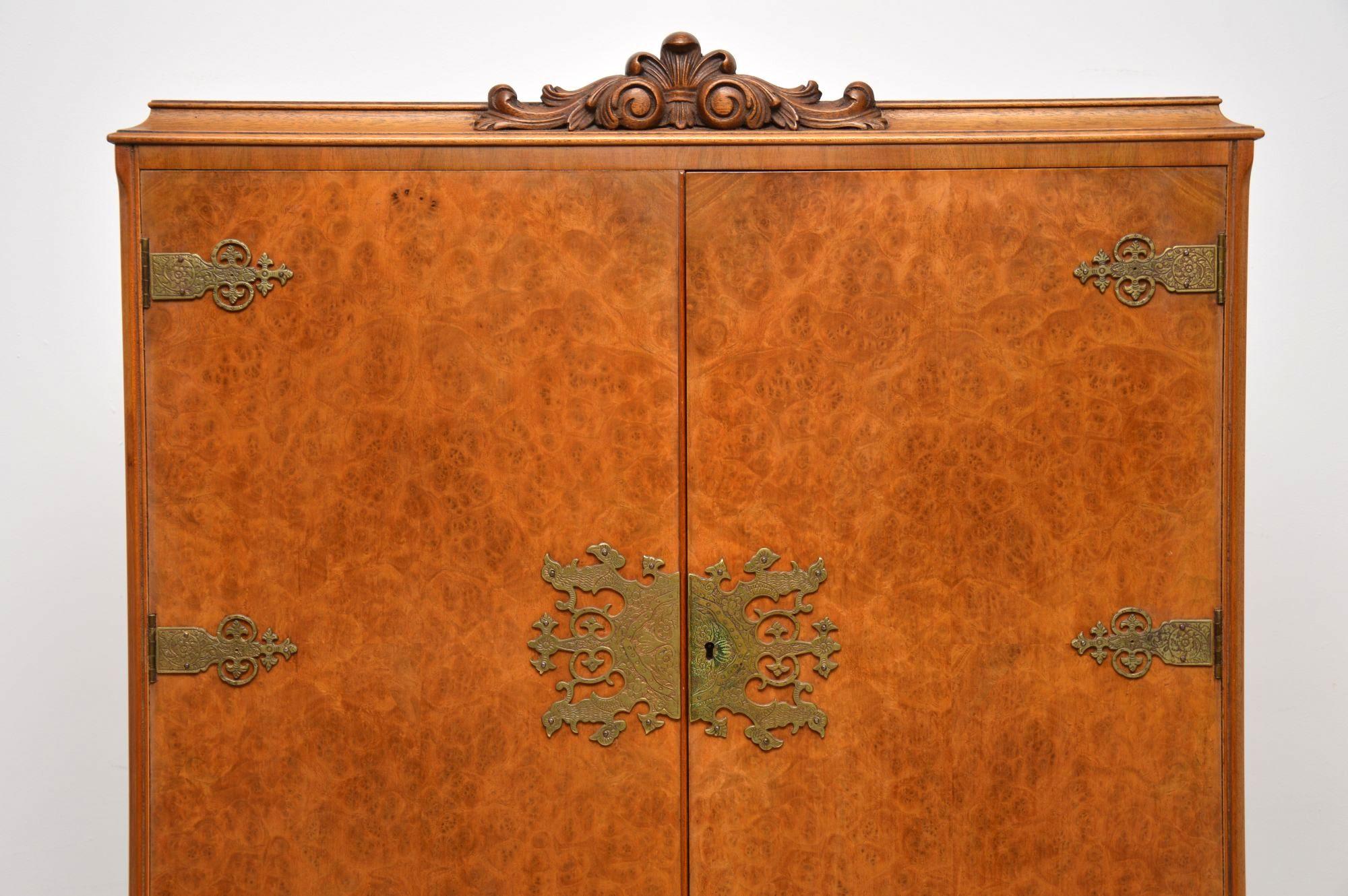 Antique Queen Anne style burr walnut cocktail cabinet in good condition and dating to around the 1930s period. It’s beautifully carved above the doors and between all the legs, which are also carved on the tops. The doors have very decorative etched