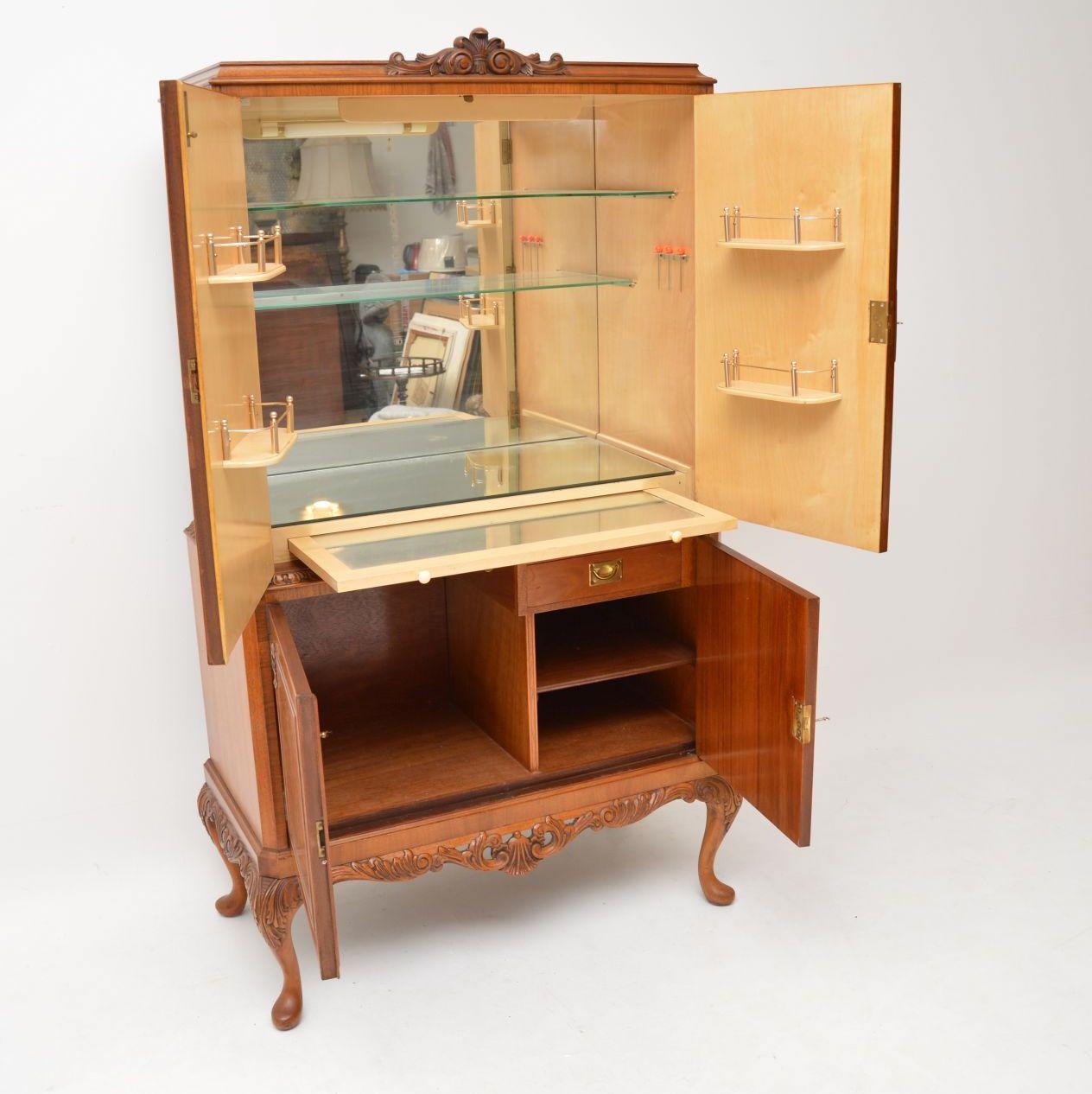 Antique Queen Anne style burr walnut cocktail cabinet in excellent original condition & dating from the 1930s period. This drinks cabinet is extremely fine quality and has many great features inside & out. It has four burr walnut doors, with a large