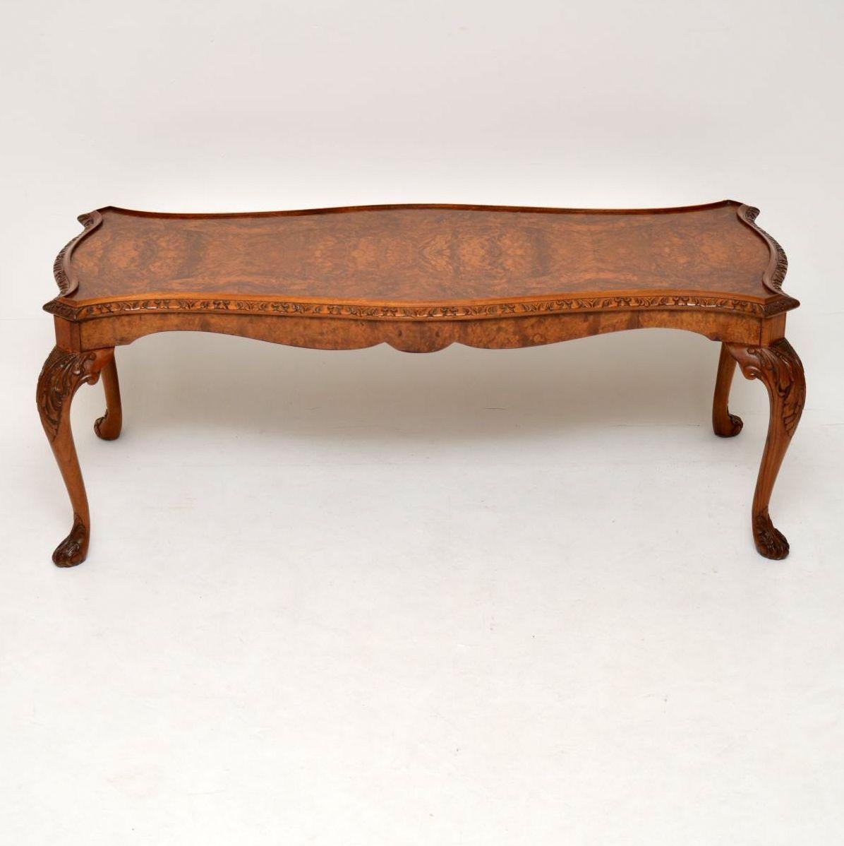 This long coffee table has a nicely patterned burr walnut shaped top & a carved top edge. The solid walnut legs are also well carved top & bottom. It’s antique Queen Anne style, dating to around the 1930s period & is in excellent condition, having