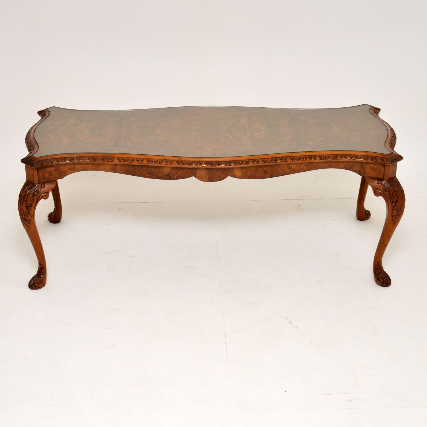 Fine quality antique Queen Anne style walnut coffee table in excellent condition and dating from circa 1930s period.

It has a shaped burr walnut top, with a carved edge and a burr walnut frieze. The solid walnut legs are finely carved on the tops