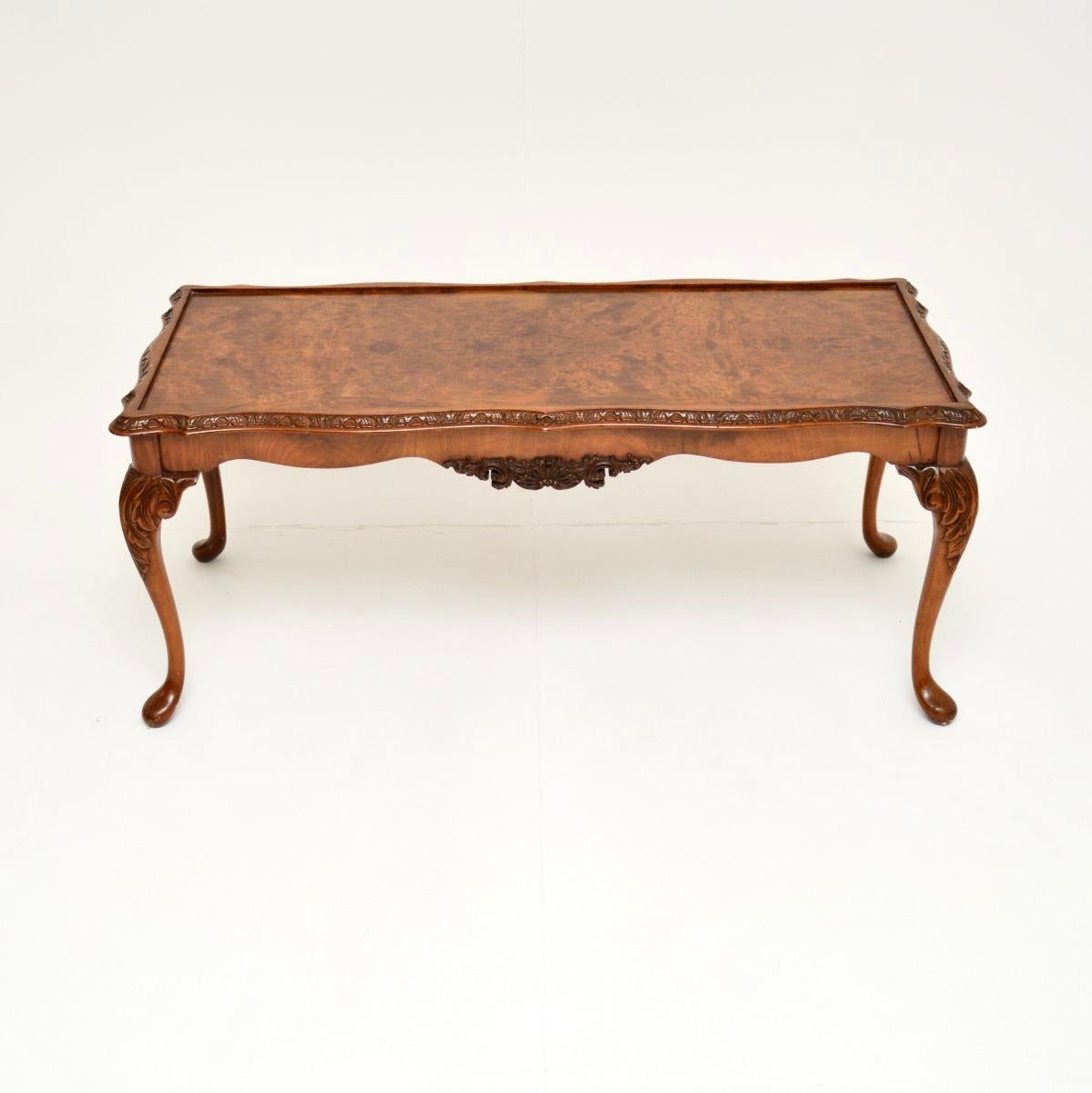 Magnifique table basse ancienne en ronce de noyer de style Queen Anne, fabriquée en Angleterre et datant des années 1950.

Ce meuble est d'une qualité remarquable. Il repose sur des pieds cabriole avec des coquilles sculptées aux genoux, ainsi que