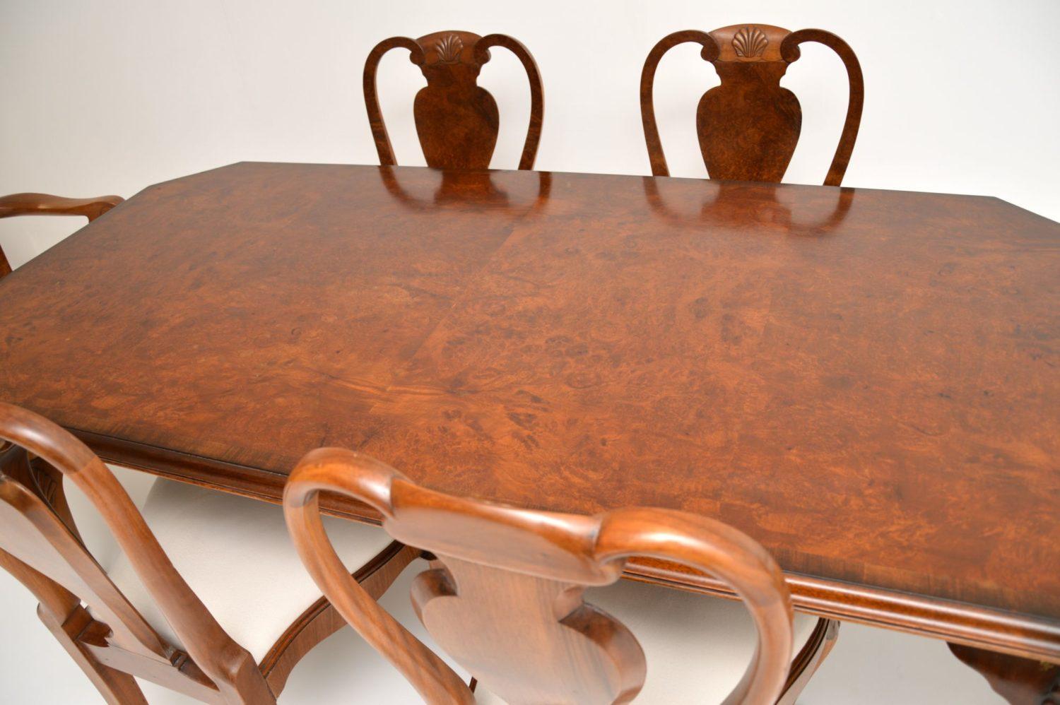 Antique Queen Anne style walnut dining table and six matching dining chairs, all in good original condition and dating from circa 1930s period. The dining table has a burr walnut top, with chamfered corners and solid walnut legs with shell carvings