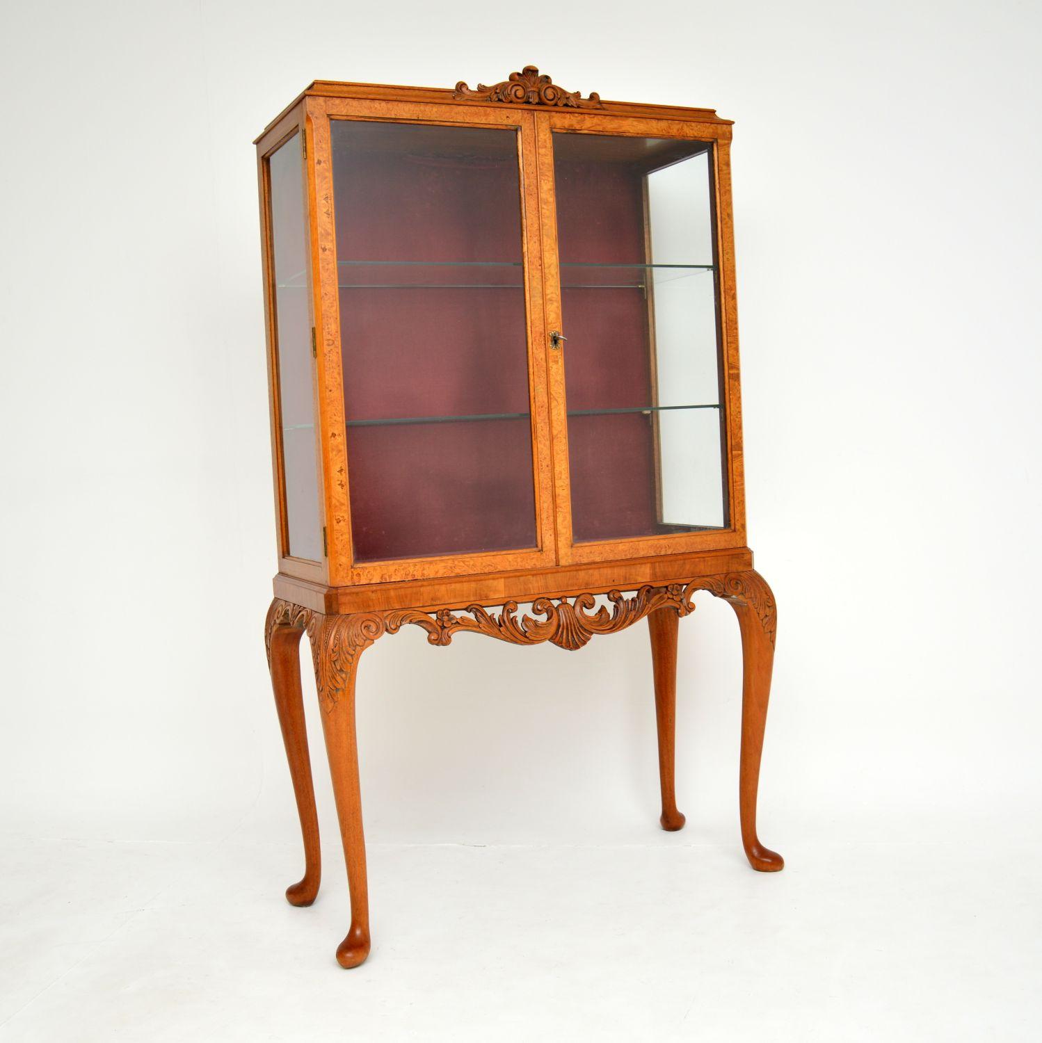 A beautiful burr walnut and glass display cabinet in the antique Queen Anne style. This was made in England, it dates from around the 1930’s.

It is a lovely size and is very well made. The burr walnut has a gorgeous light colour tone, and there