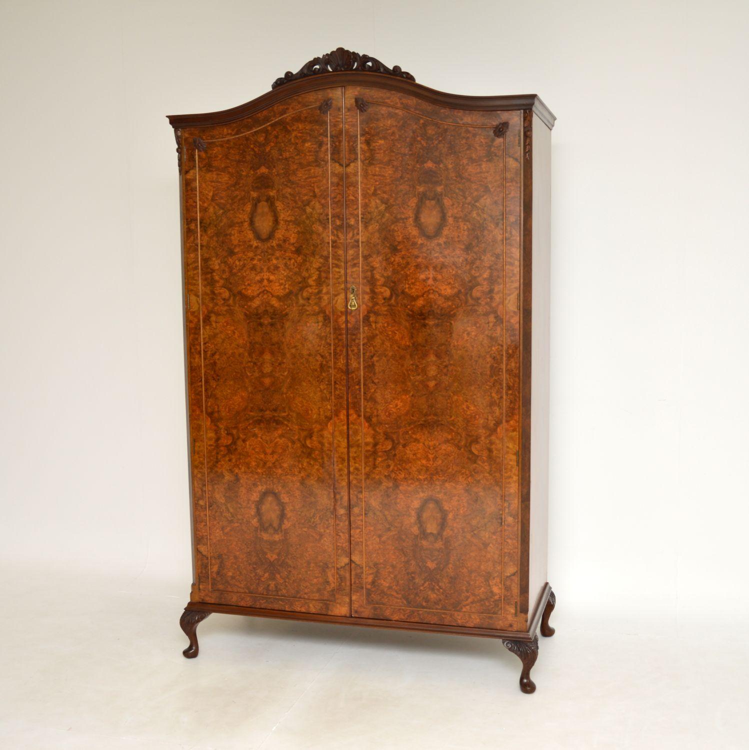 A very practicable and large walnut wardrobe in the antique Queen Anne style. This was made in England, it dates from around the 1930s period.

It is of super quality, with lots of storage space. The front is beautifully made from burr walnut, the