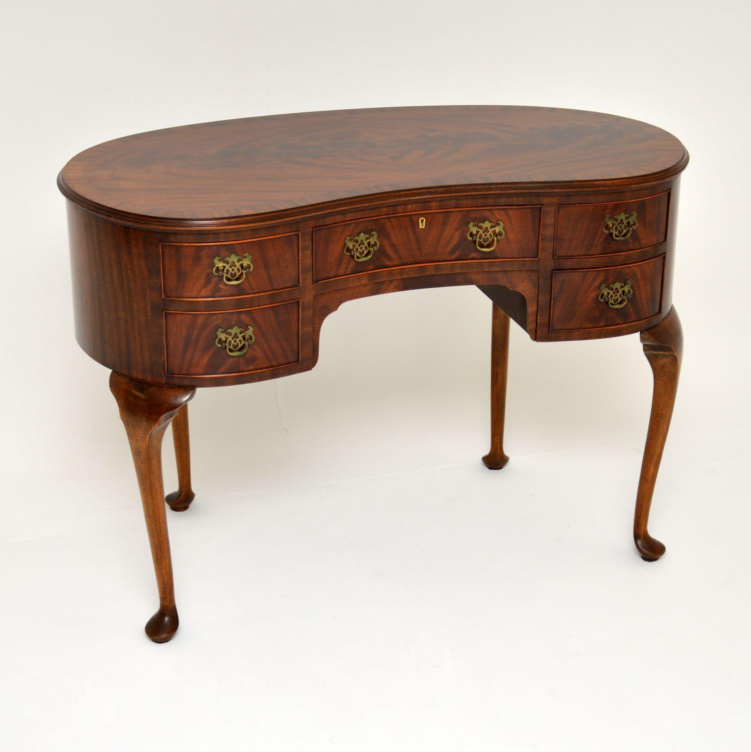 A lovely and top quality antique flame mahogany kidney shaped desk or dressing table. This dates from circa 1920s-1930s period.

It is extremely well made, with stunning flame mahogany veneers and a solid mahogany construction. The brass handles