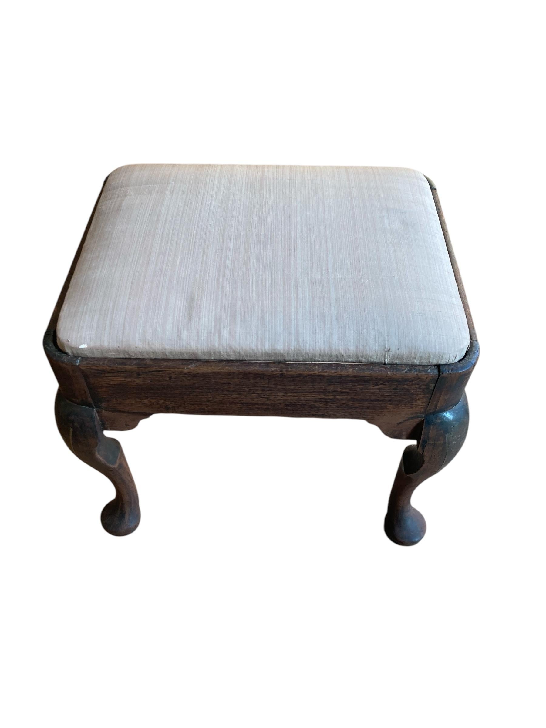 Antiguo escabel de roble de estilo Queen Anne, con patas cabriolé y asiento tapizado de estilo punto de aguja. Este precioso taburete está en un estado robusto, hacia 1925.

H: 40 cm

An: 46 cm

D: 38 cm