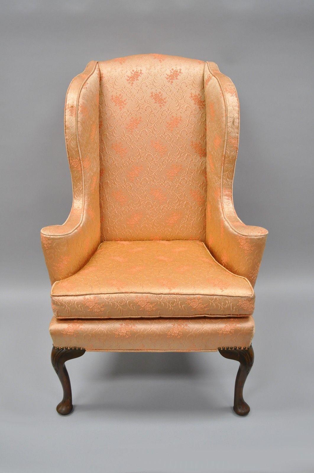 Antique Queen Anne wingback armchair with rolled arms. Item features dramatic Queen Anne legs, uniquely shaped wing-back, solid wood frame, upholstered seat, and quality American craftsmanship, circa early 1900s. Measurements: 49