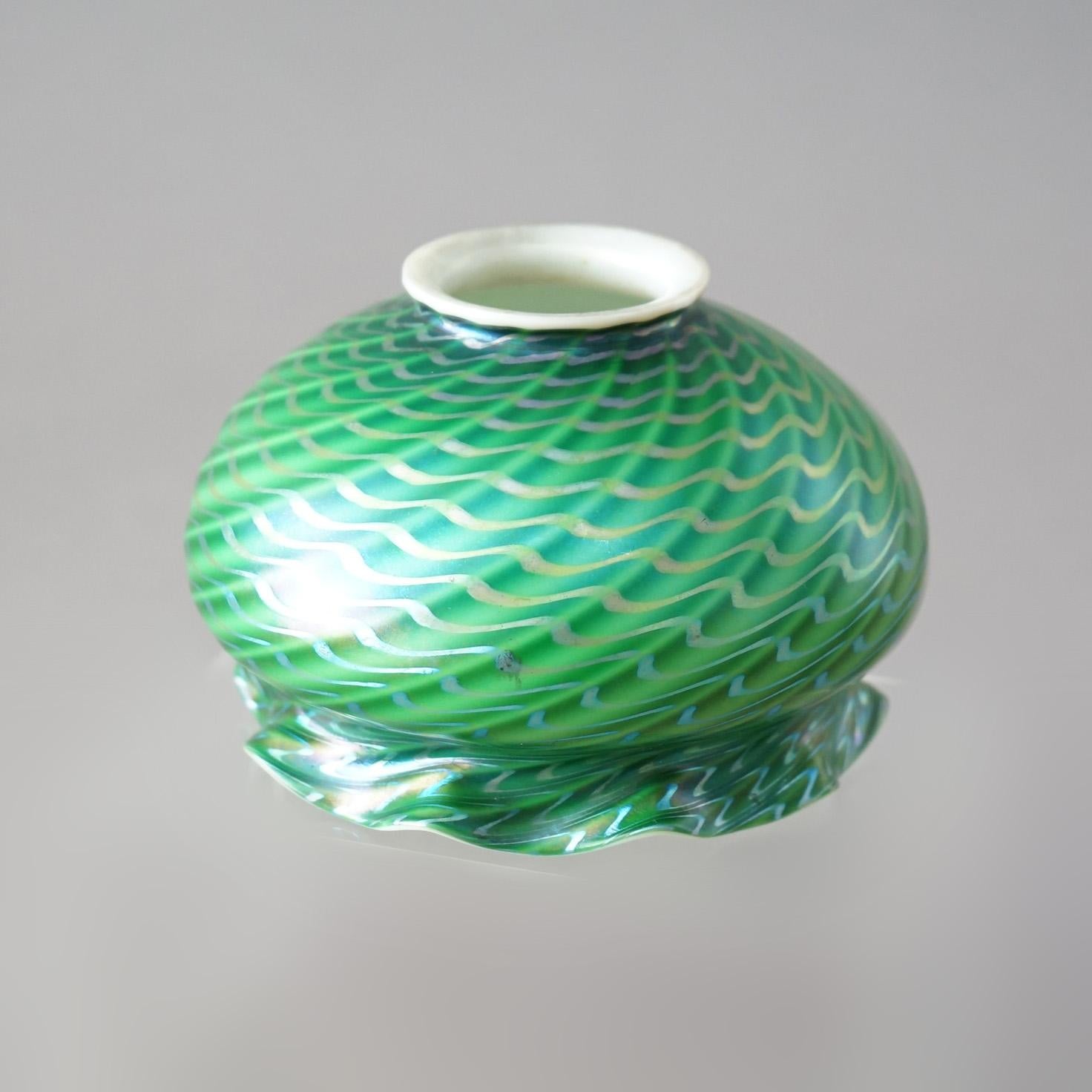An antique lamp shade in the manner of Quezal offers emerald green swirl art glass construction with ruffled rim and gilt decoration, c1920

Measures - 3.75