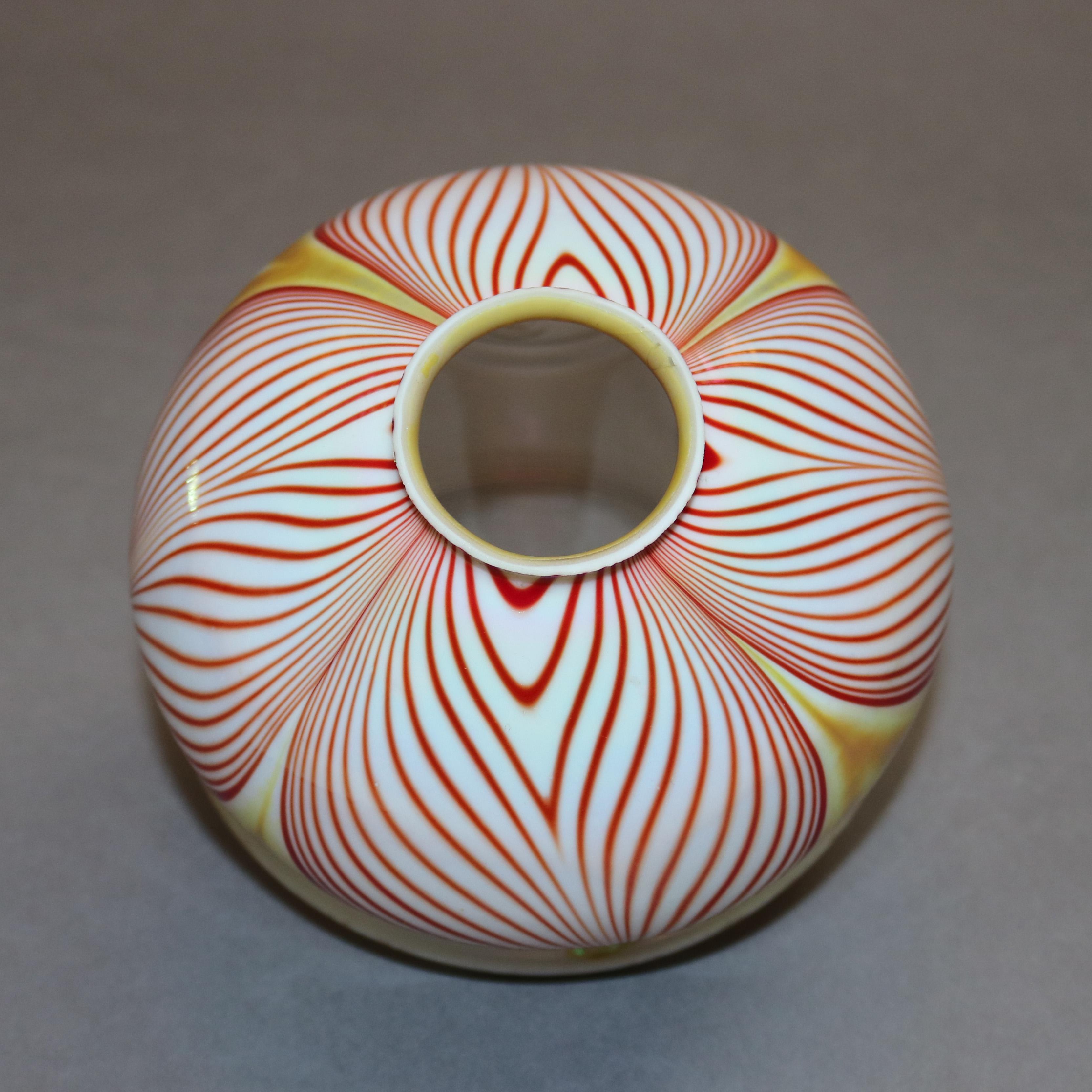 An antique art glass lamp shade in the manner of Quezal having bulbous form and red, white and gold pulled feather design with gold interior and flared rim, signed Zephyr Glass on collar interior as photographed, 20th century

Measures: 3.75