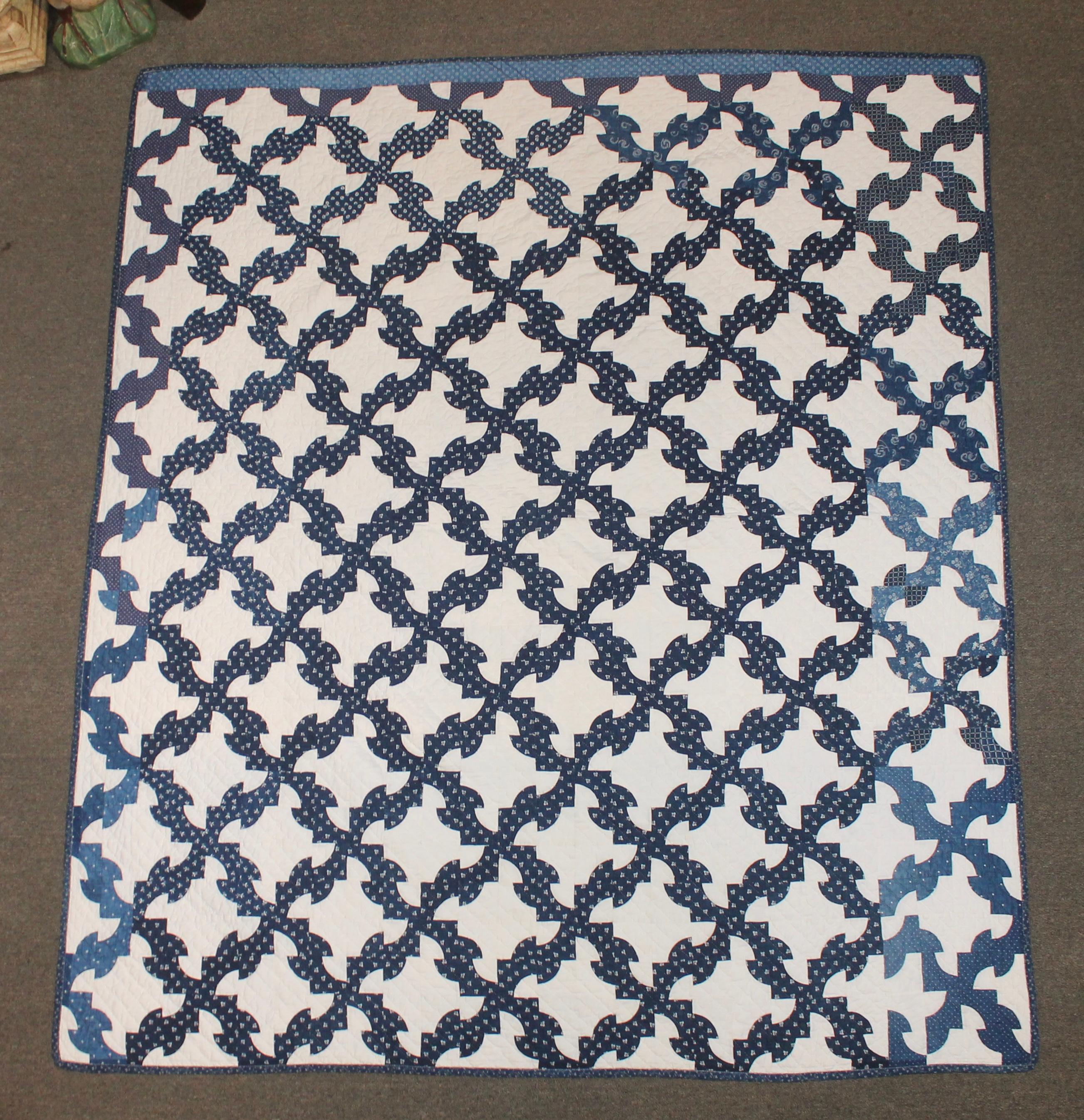 This fine geometric blue and white drunkers/drunkard's path pattern quilt is in different calico blues and in good condition. One edge is in a faded blue calico fabric. This quilt is quite clean and nice piecework.