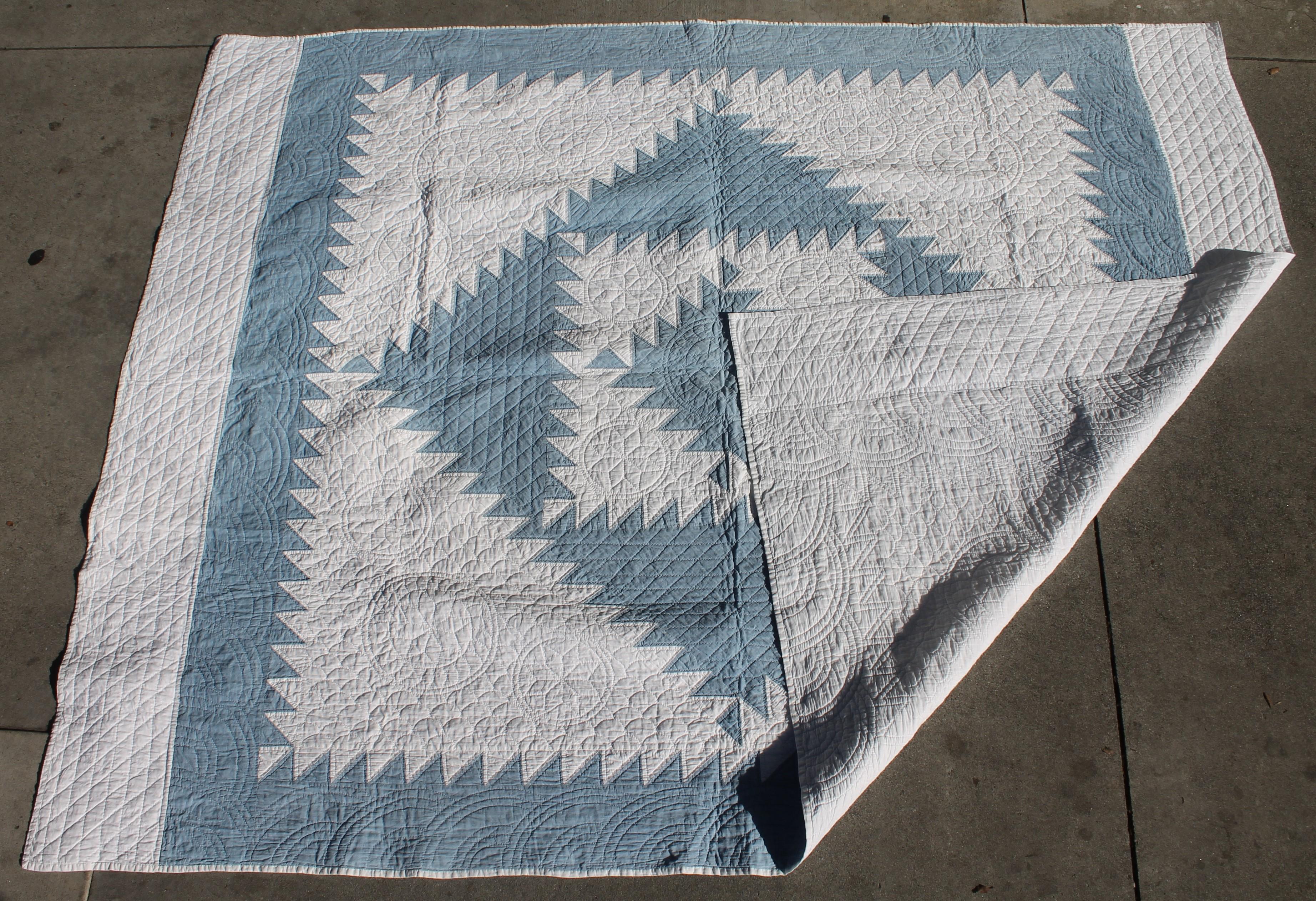 This antique quilt is in a sky blue and white fabric with heavily quilted and fine piece work. The condition is pristine.