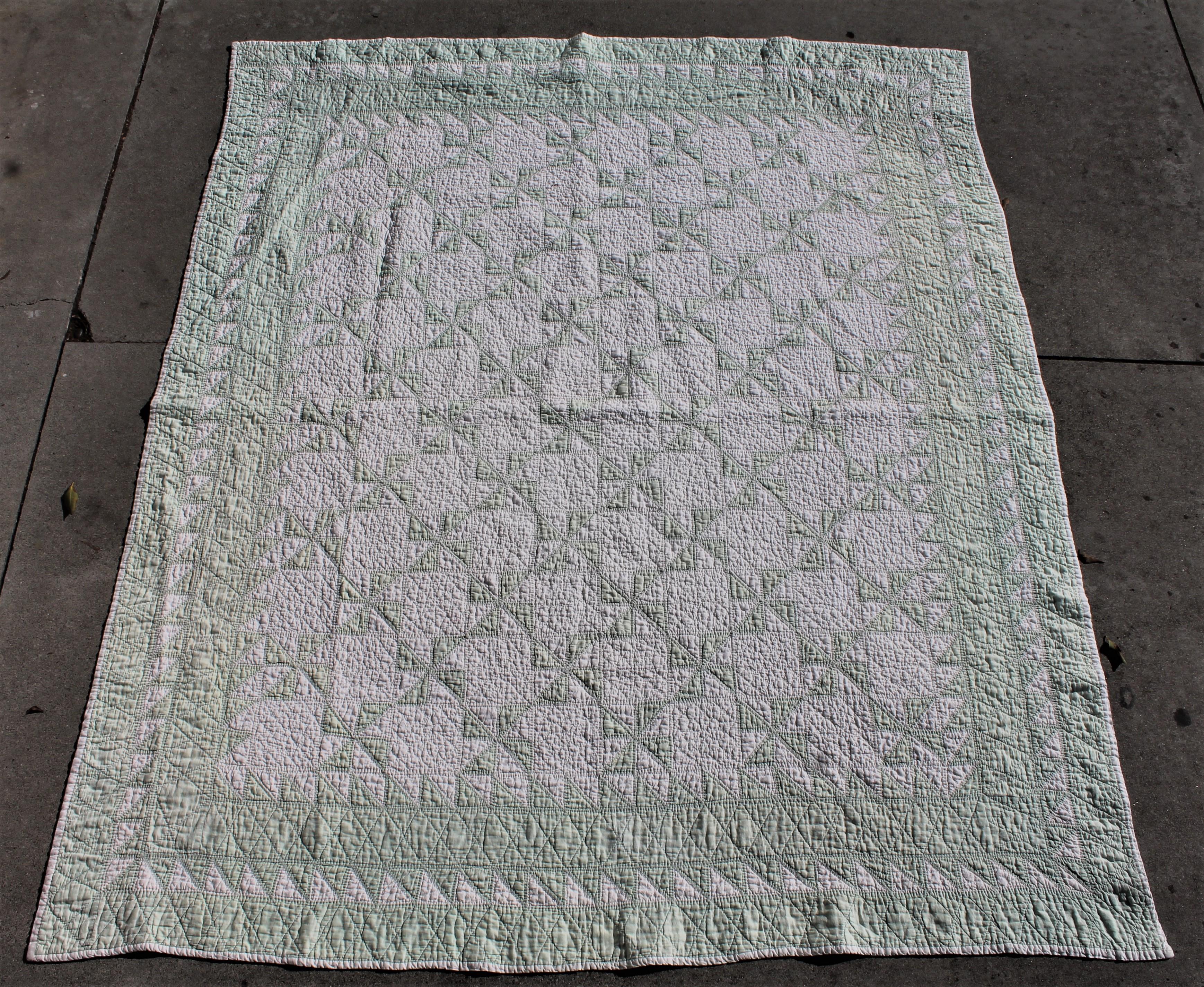 This fine small pin wheels quilt is a light green with a inner saw tooth border. Over light faded through out the body of the quilt.
