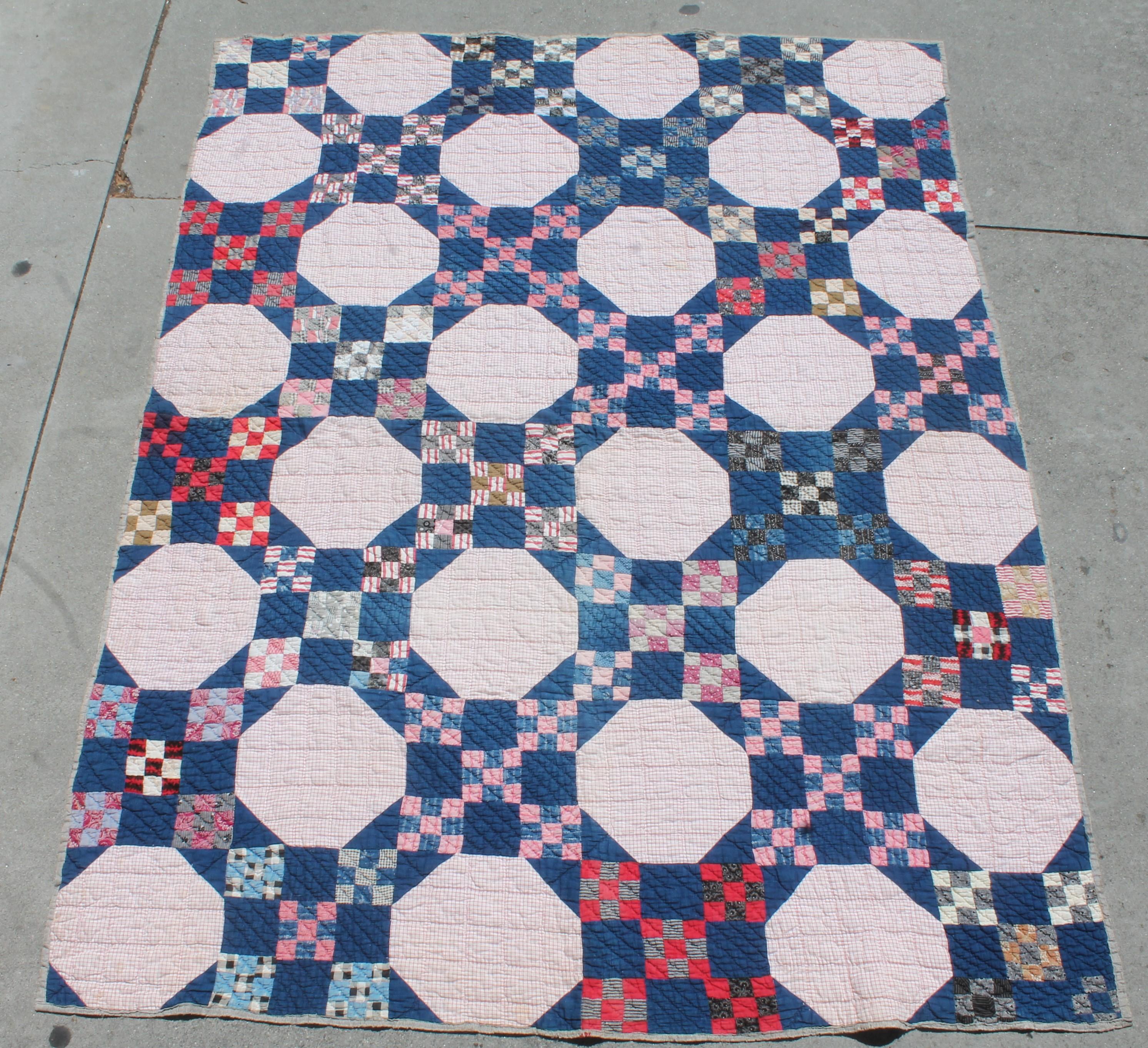 This early red, white and blue calico and indigo blue fabrics has a homespun backing. The binding edges have been repaired in some areas a long time ago. The quilts is in good condition otherwise.
