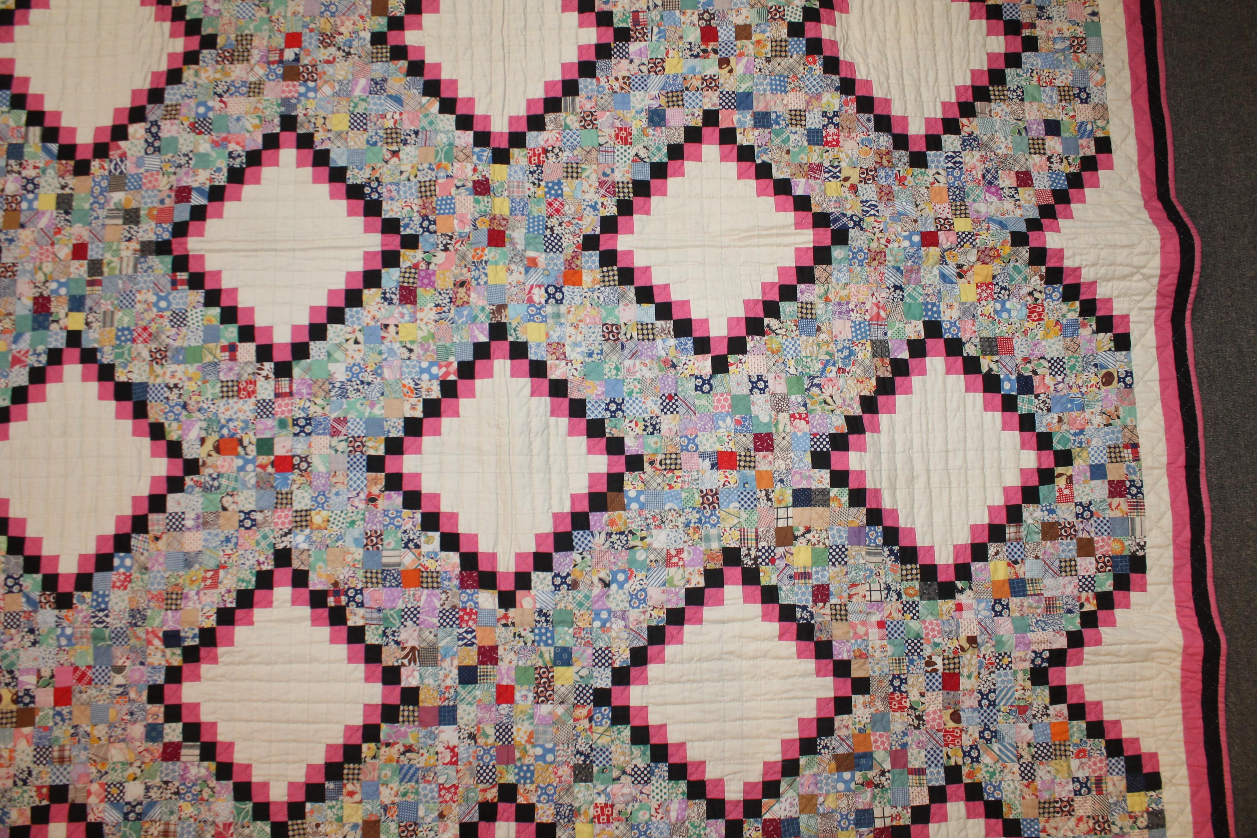 This fine tiny postage stamp Irish chain quilt is in pristine unwashed , never used condition. This amazing beauty has a black and pink trim and triple borders. This fine quilt was found in Ohio and has a pink polished cotton backing. The piece wok