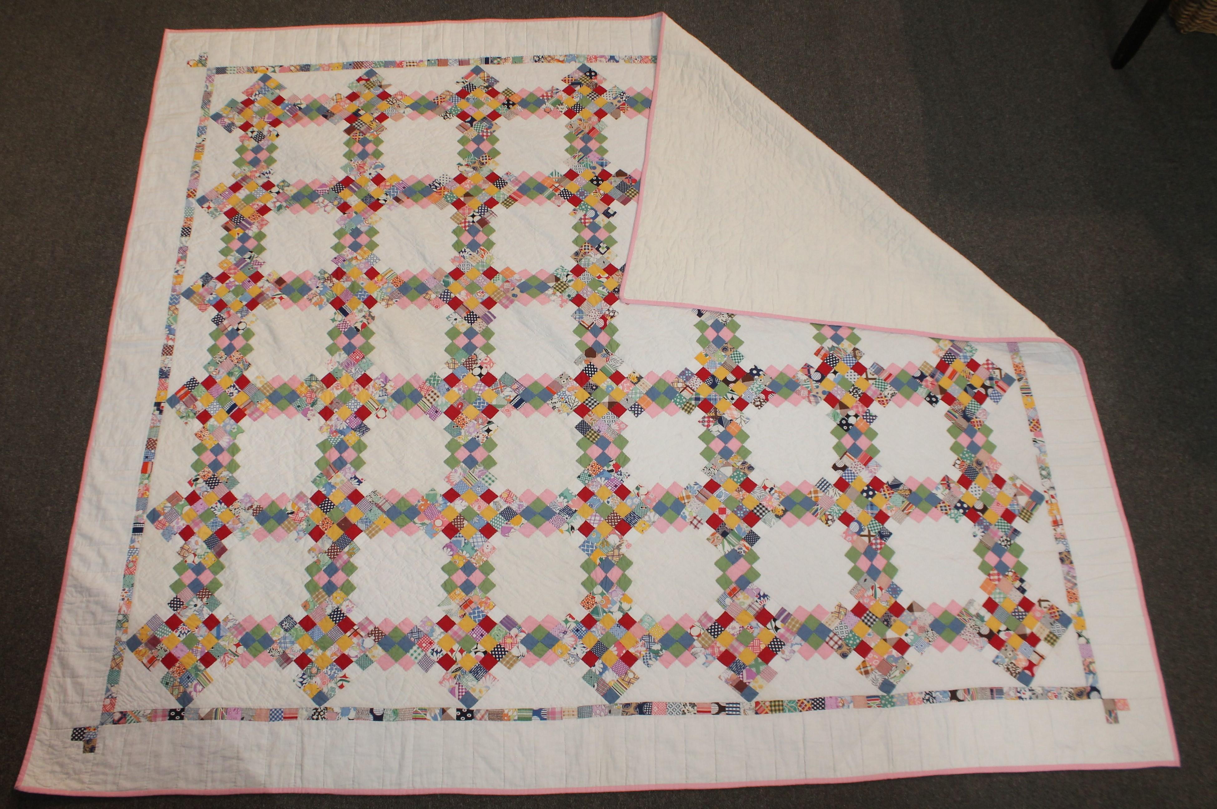 This early 20th century postage stamp triple Irish chain quilt in pristine condition. This candy striped inner border is in postage stamp formation. The condition is mint.