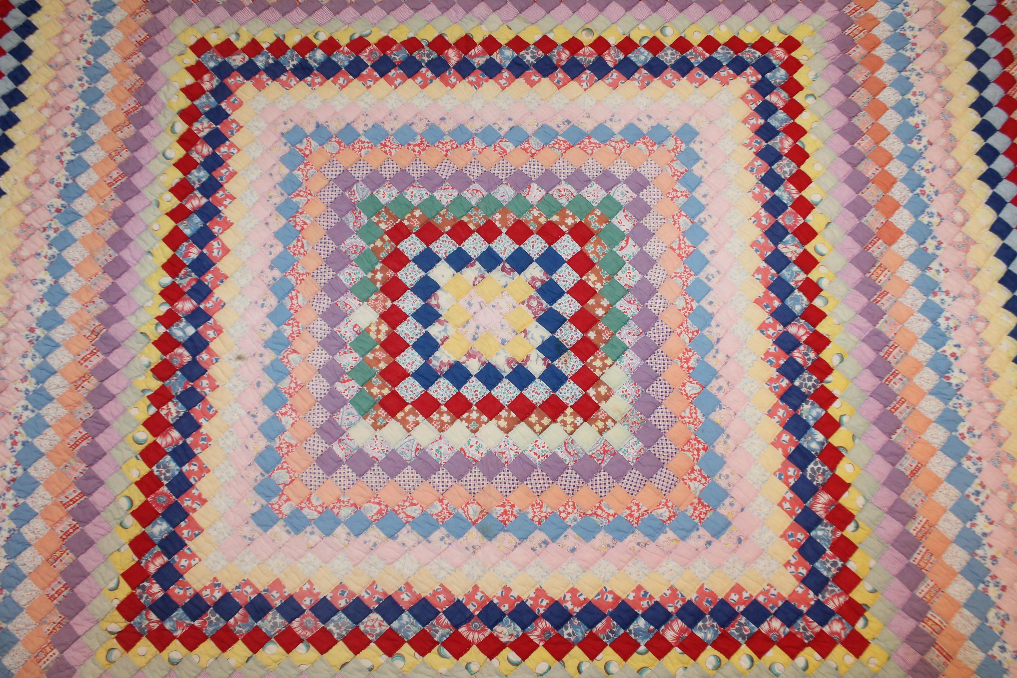 This finely pieced postage stamp trip around the world pattern quilt is in good condition and resembles Easter or spring colors. The condition is good and great for a girls room.