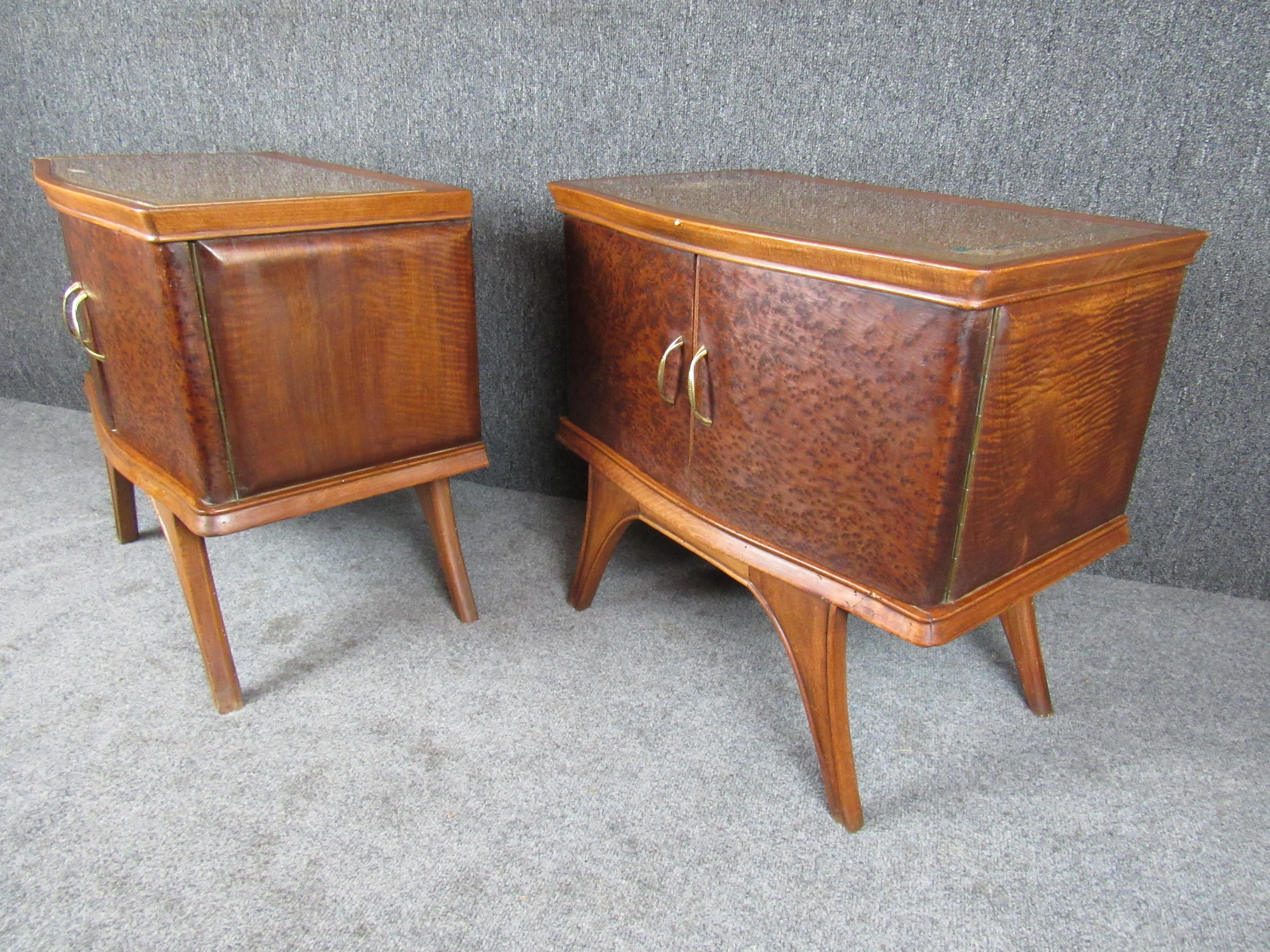 Wonderfully charming pair of sculpted Italian wooden nightstands from the early 20th century. Blending Art Deco design with early modern influences, these bedside cabinets feature curved doors, painted glass tops, and flowing carved legs to make the