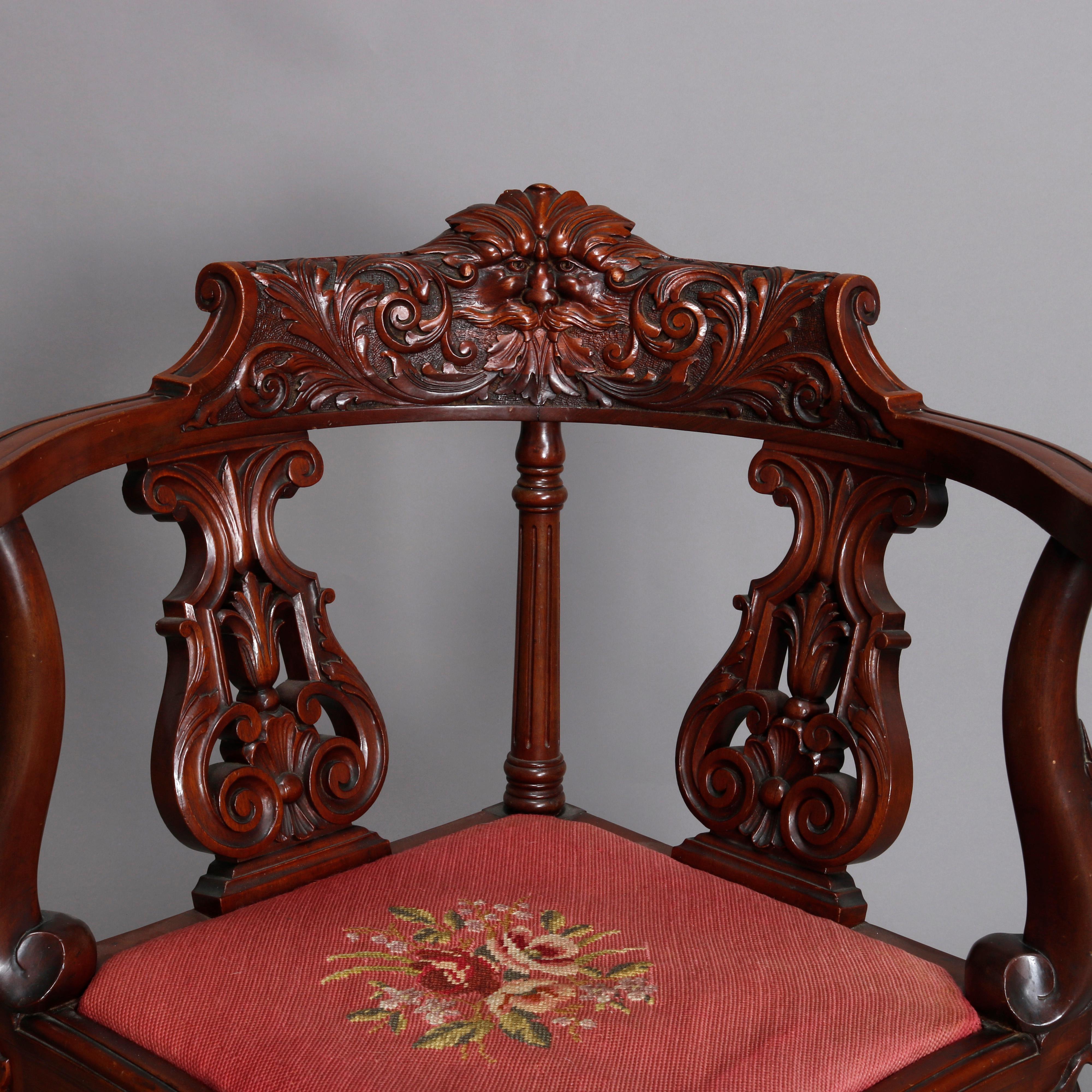 An antique corner chair by R. J Horner offers deeply carved mahogany construction with crest having North Wind face flanked by scroll and foliate decoration surmounting back having pierced urn form and turned elements, scroll form arms with scroll